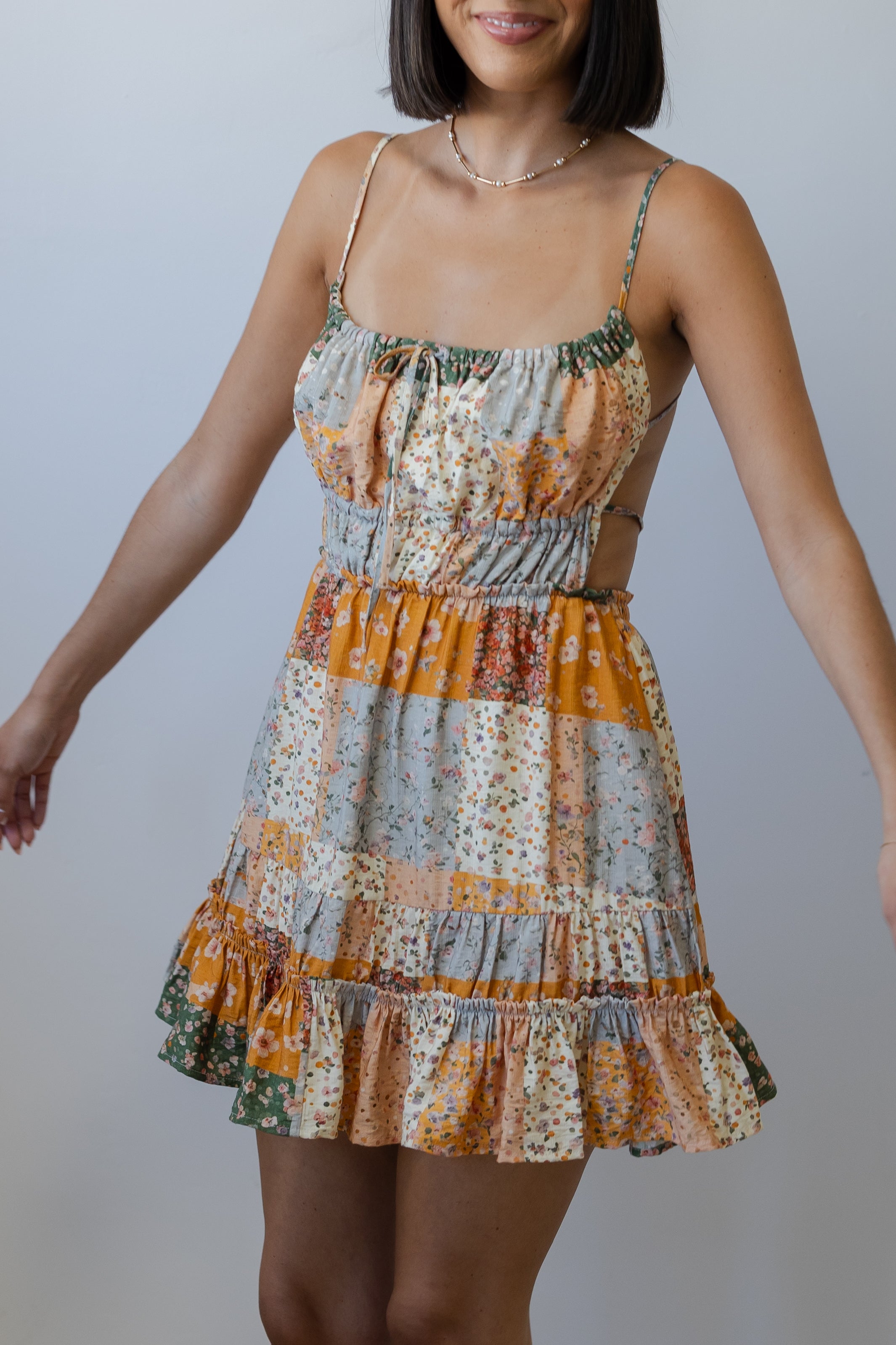 Woman wearing a patterned dress against a plain background