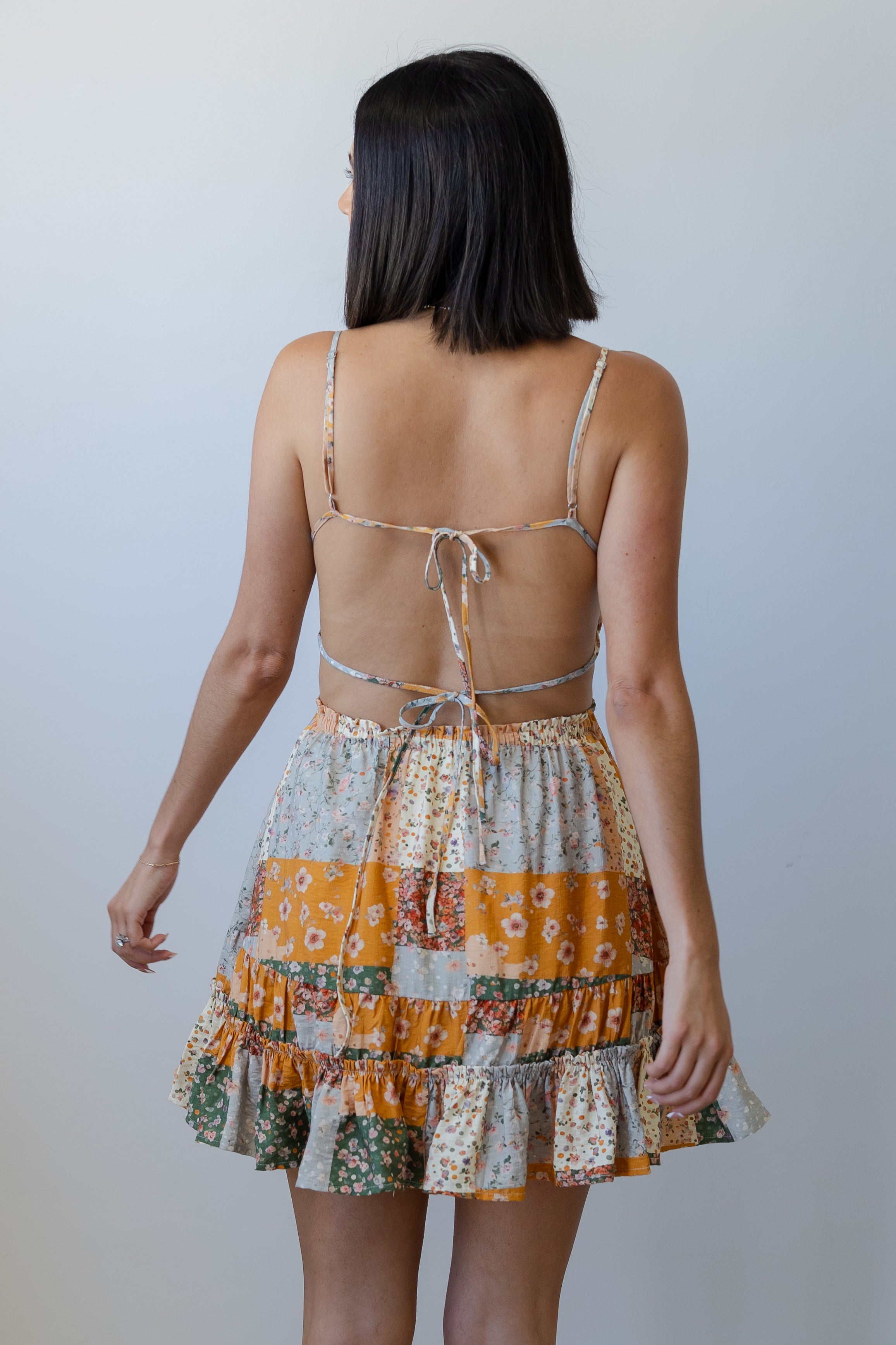 Woman wearing a patterned dress with a plain background