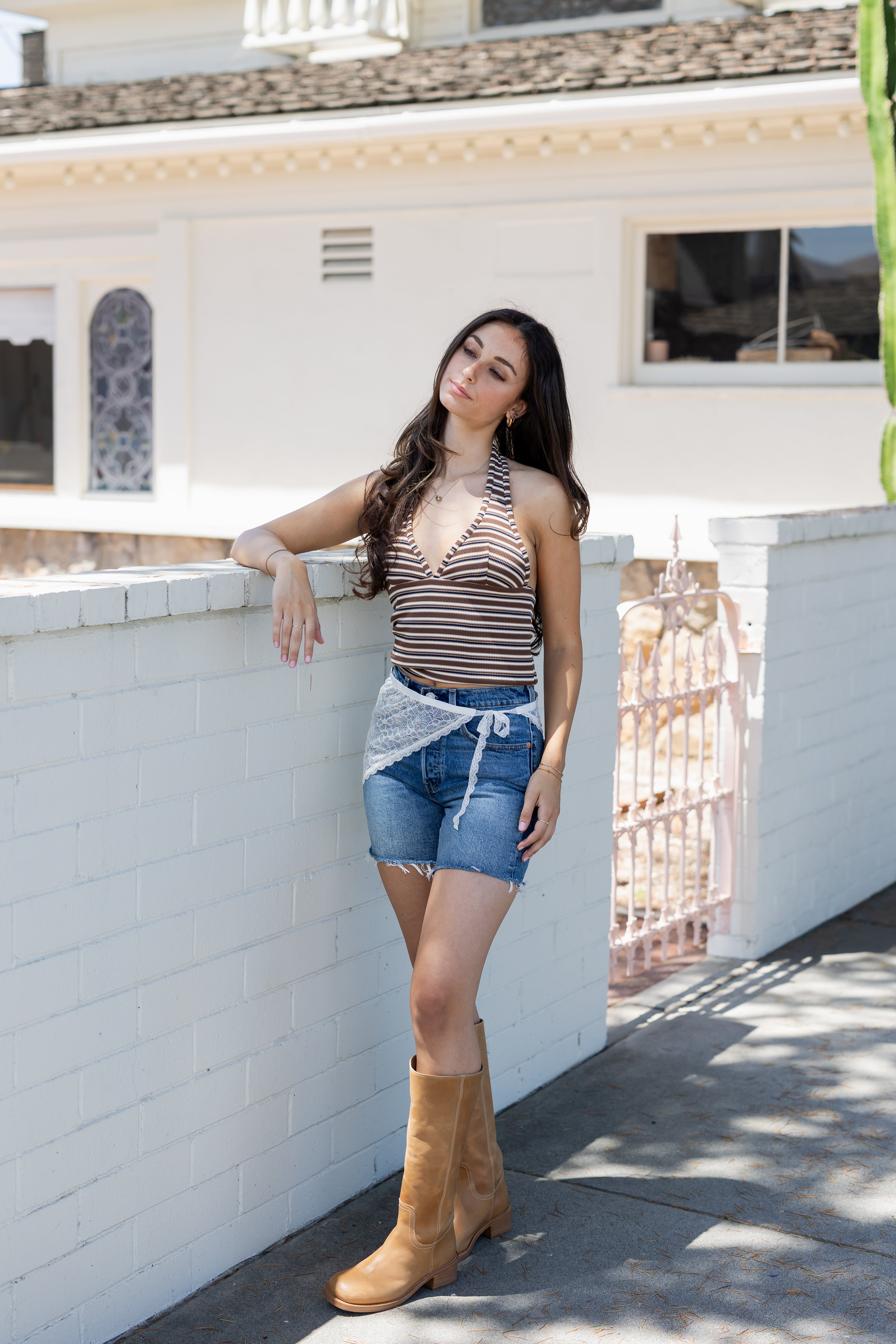 Woman standing on a rooftop with a white building in the background