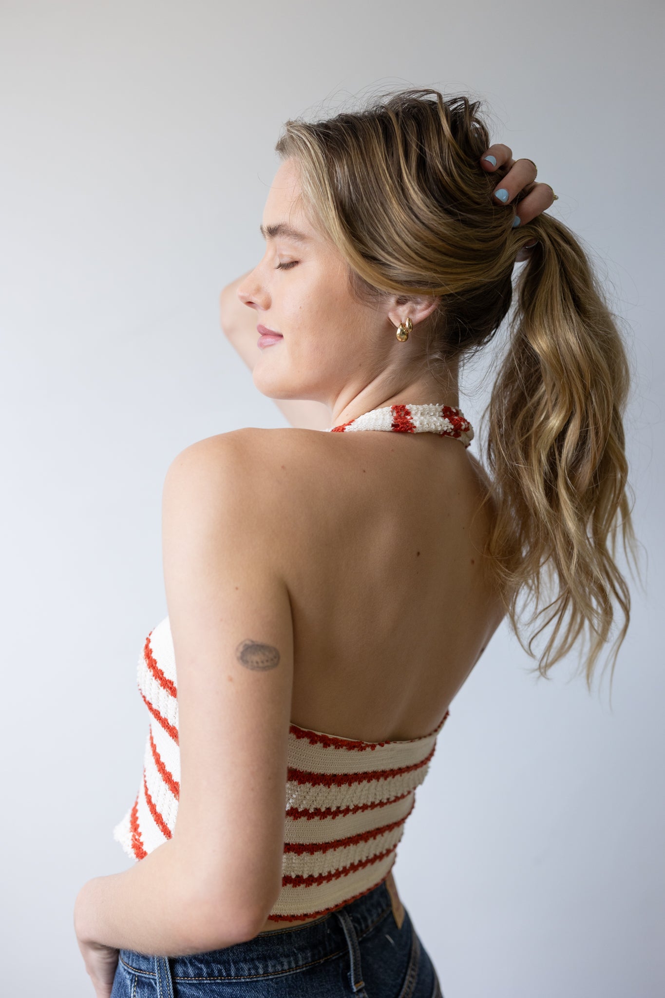 Woman wearing a red and white striped top with a plain background