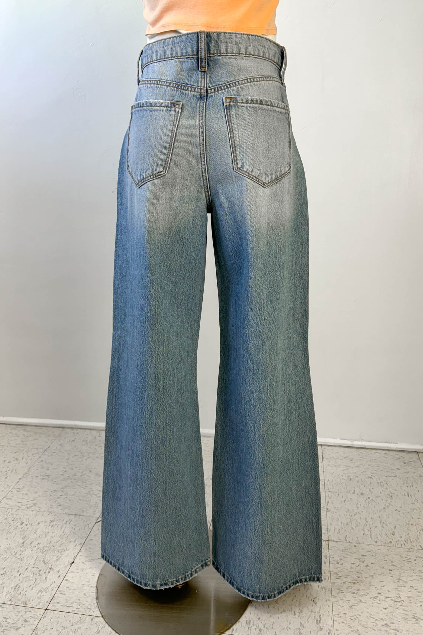 Wide-leg jeans on a stand against a plain background