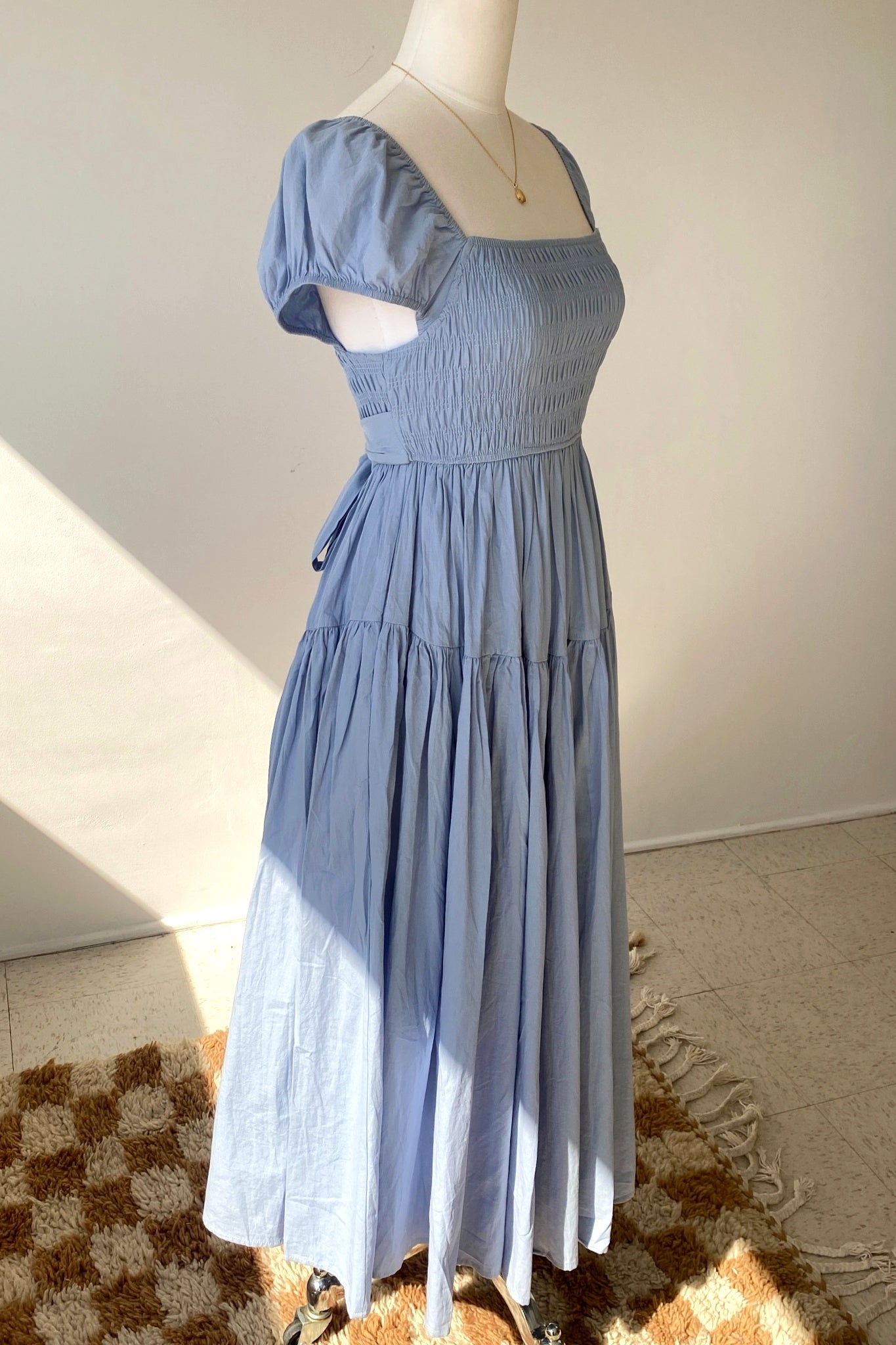 Blue dress on a mannequin against a neutral background