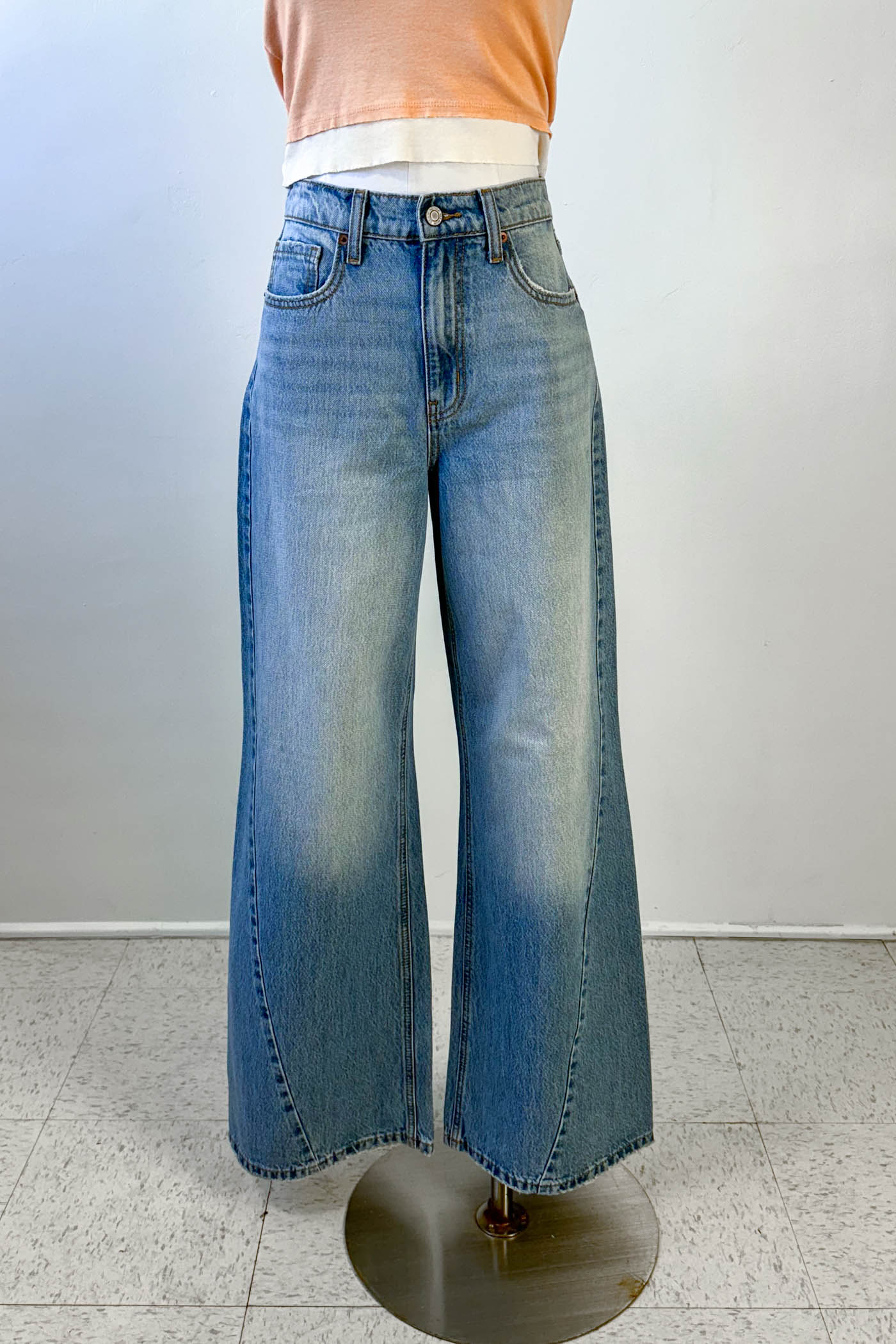 Mannequin wearing blue wide-leg jeans against a plain background