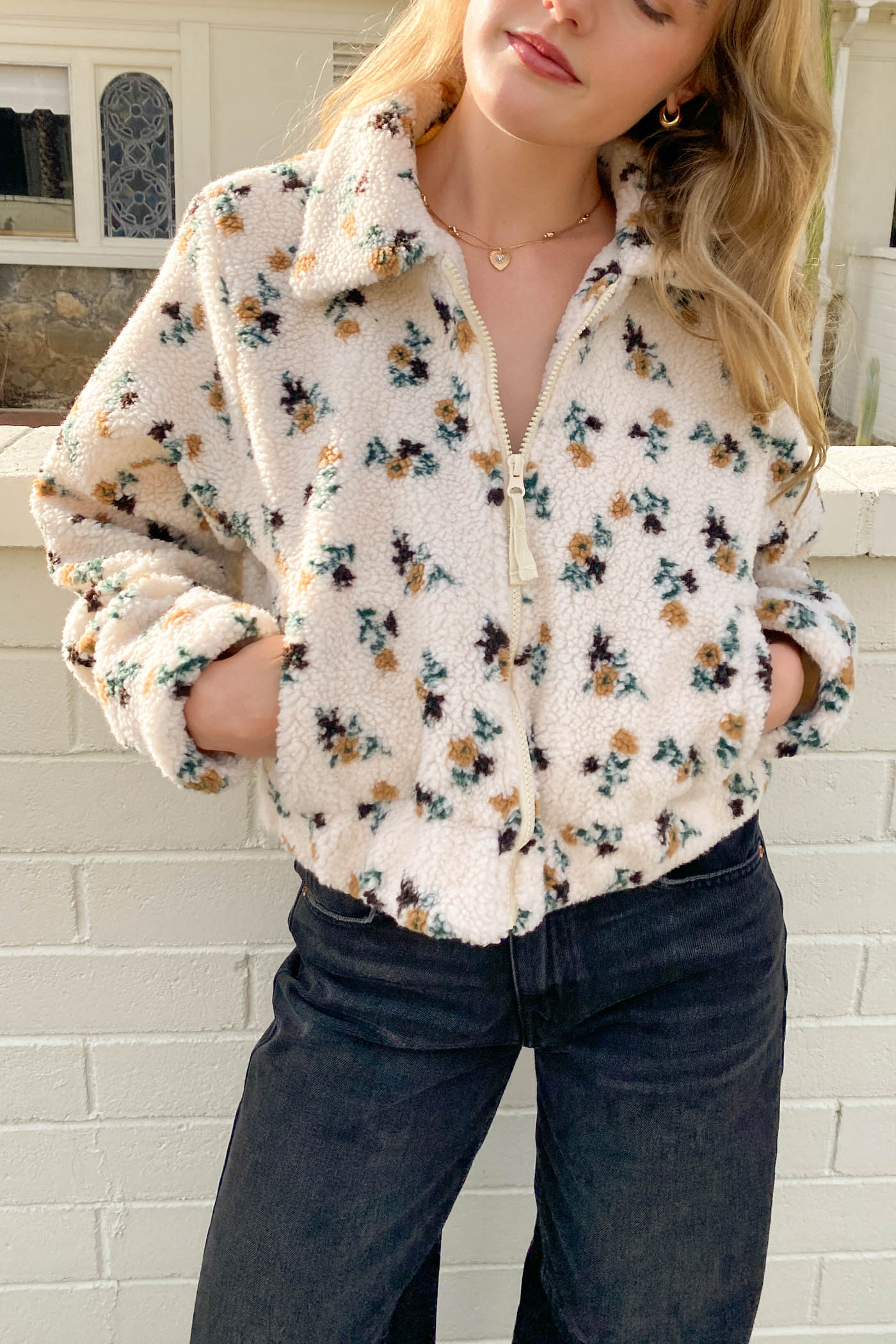 Person wearing a floral patterned shirt with a white background