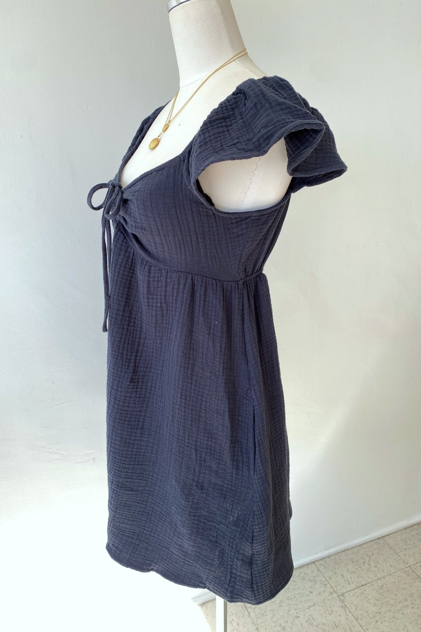Navy blue dress on a mannequin against a white background