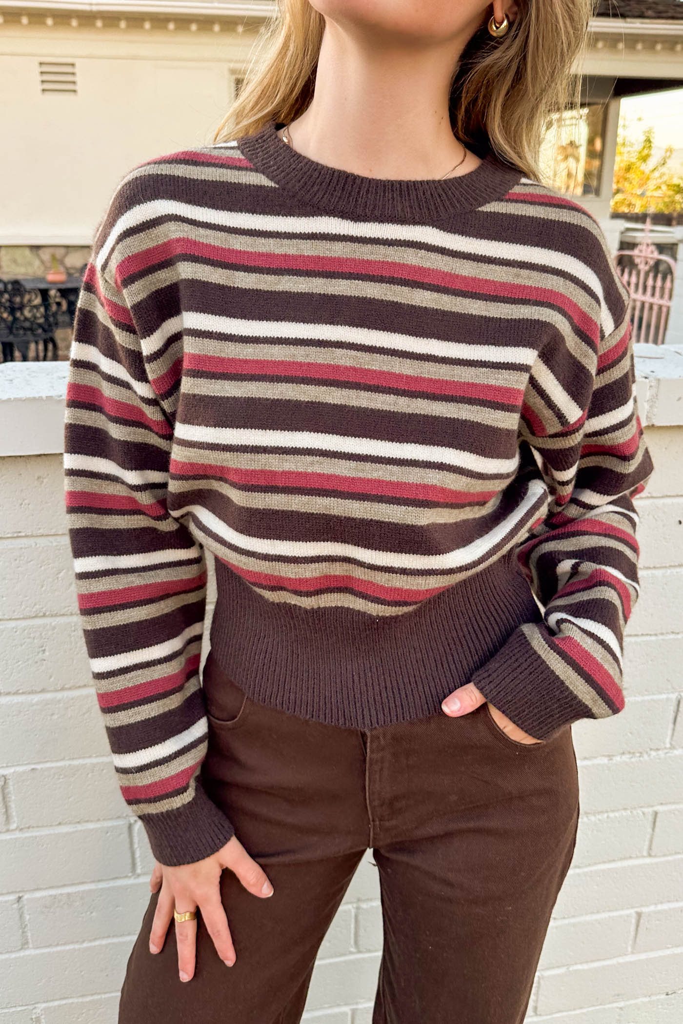 Person wearing a striped sweater with a blurred background