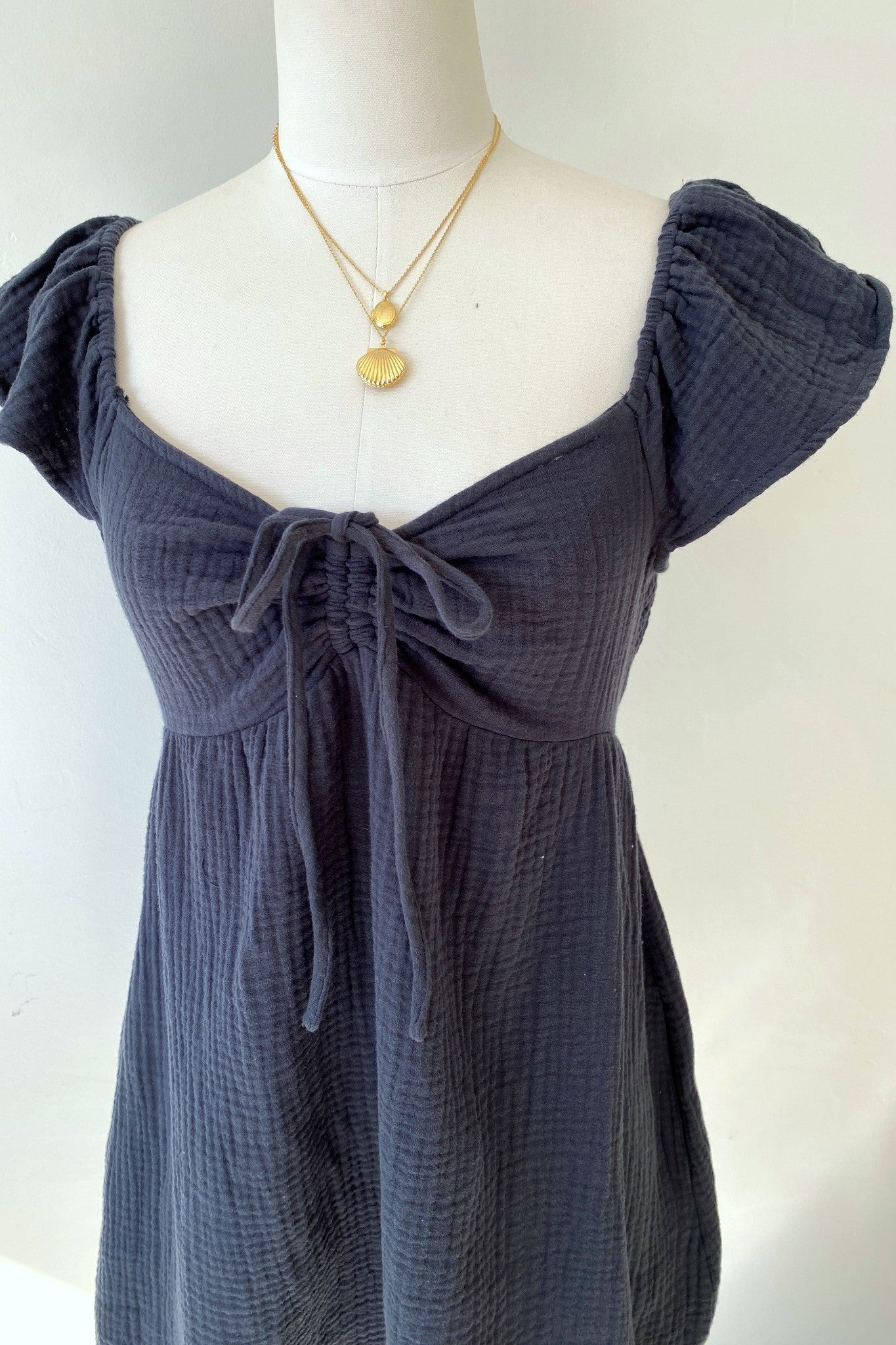 Navy blue dress on a mannequin with a plain background