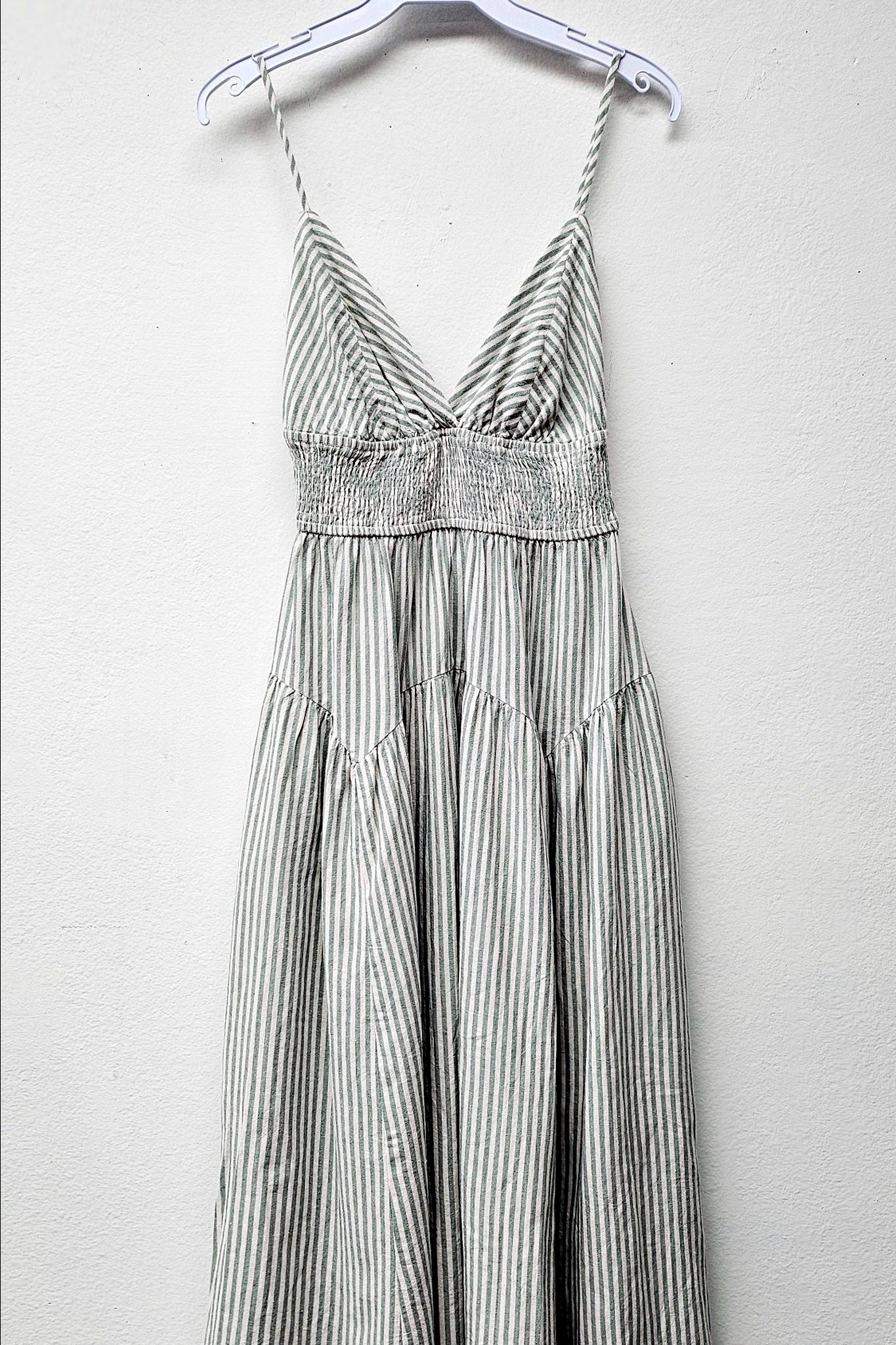 Striped dress on a hanger against a plain background