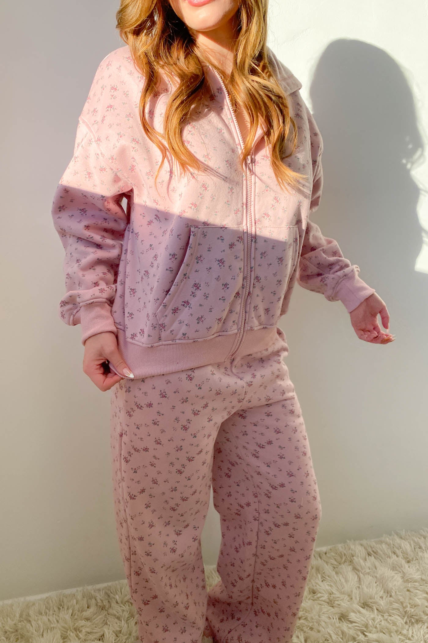 Person wearing a matching pink and purple floral pajama set against a plain background