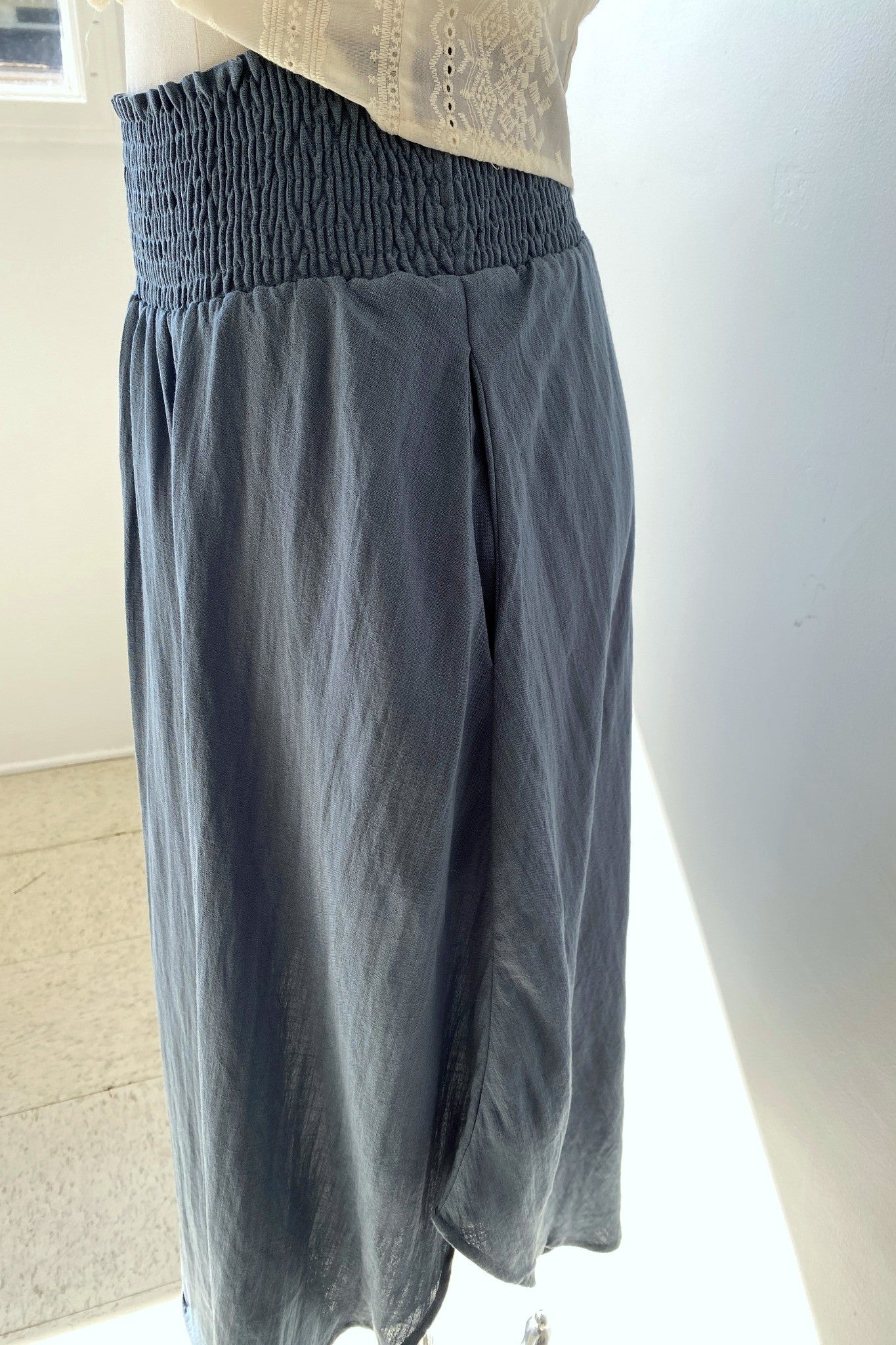 Gray wide-leg pants on a mannequin against a neutral background