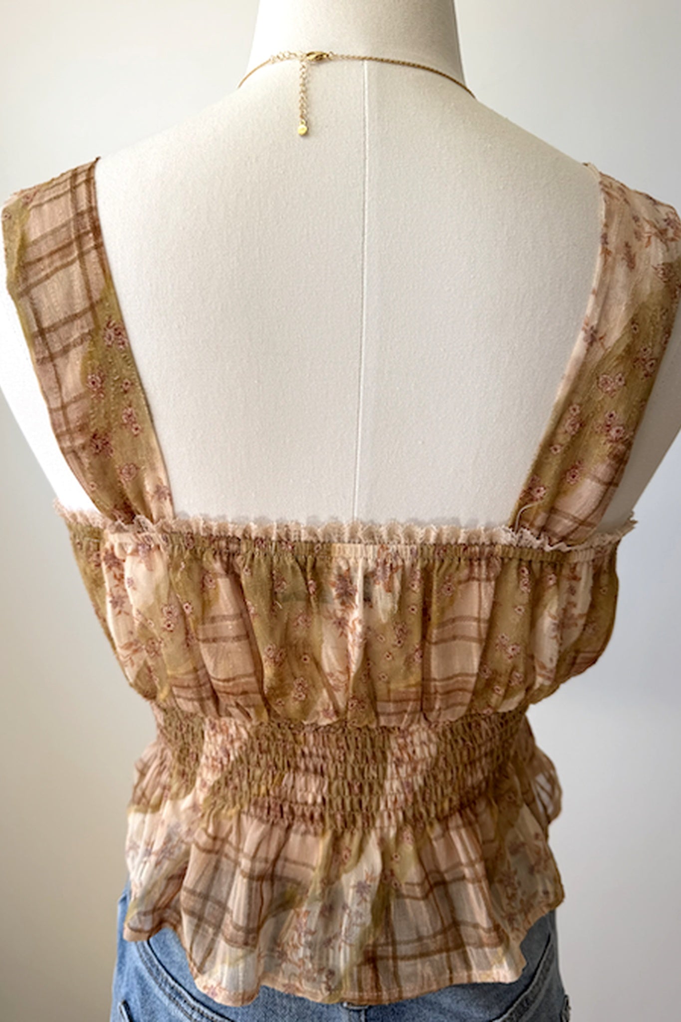 Brown plaid top on a mannequin with a plain background