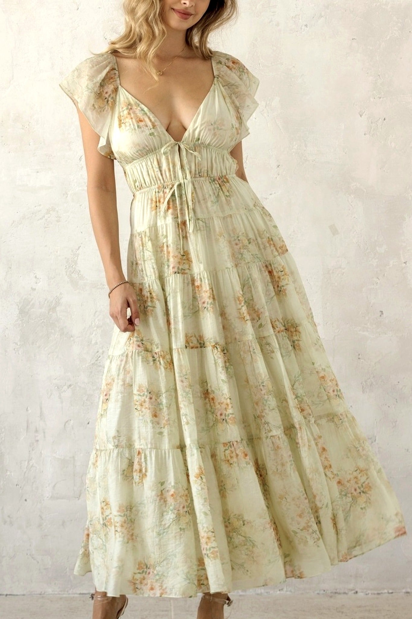 Woman wearing a floral dress against a plain background
