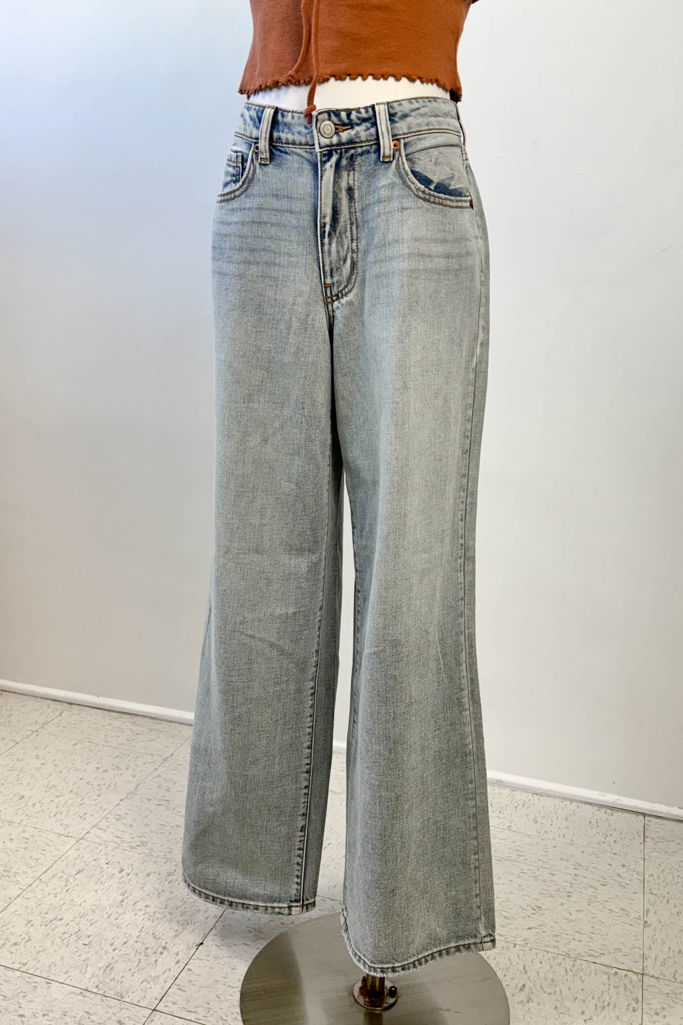 Light blue jeans on a stand against a white background