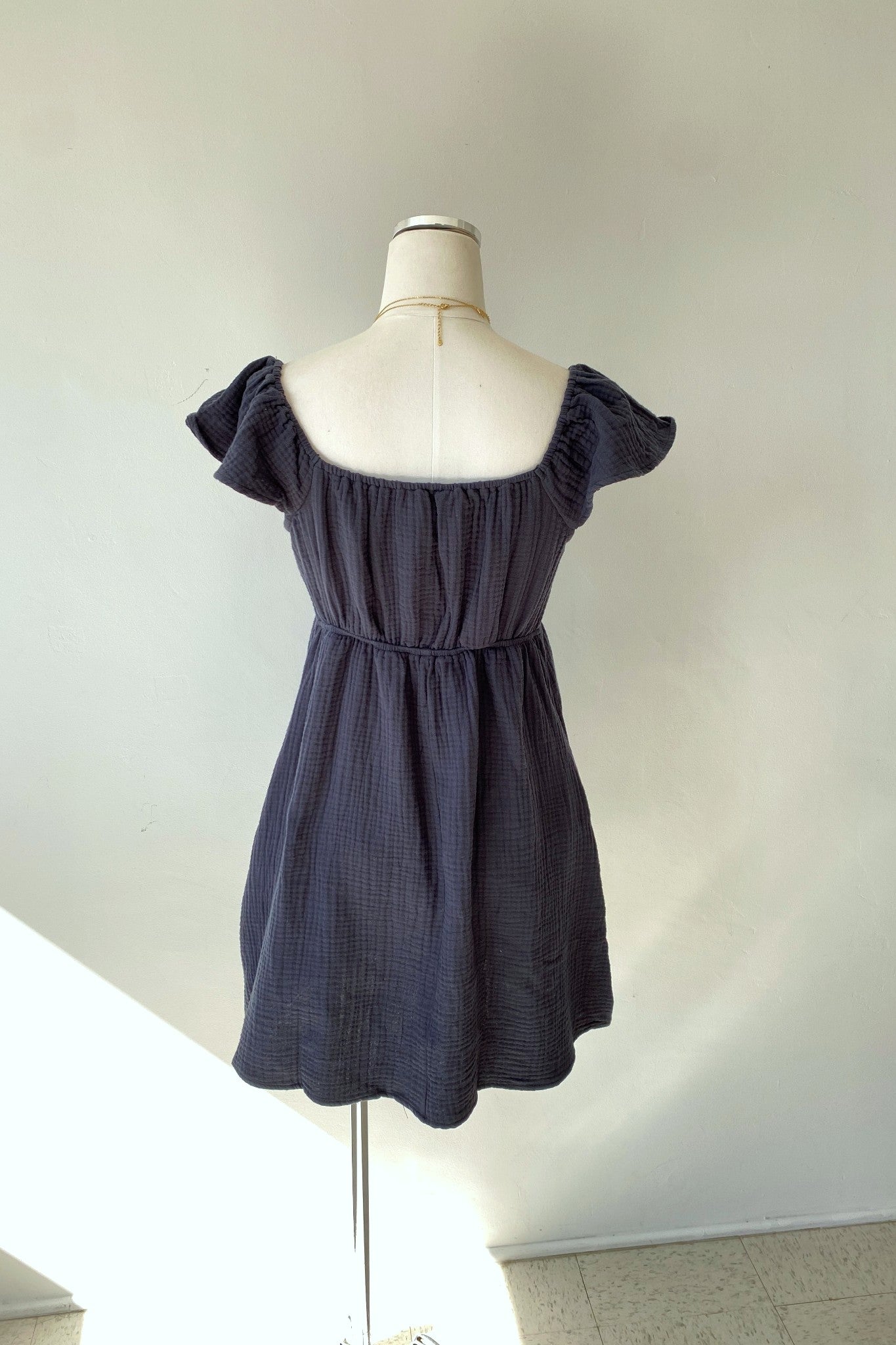 Navy blue dress on a mannequin against a plain background