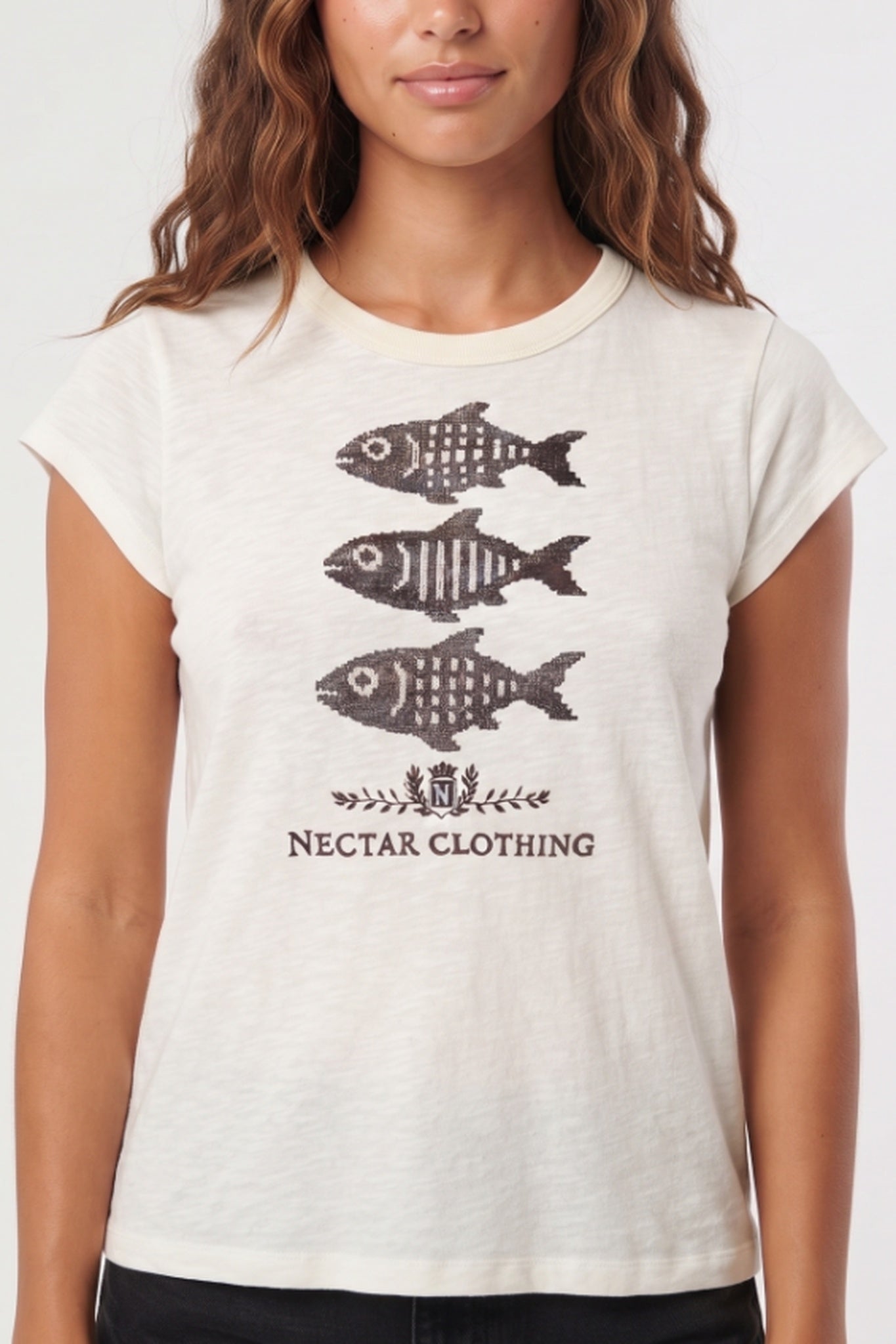A woman wearing a light beige short-sleeve t-shirt with a graphic of three fish and the text 'NECTAR CLOTHING' printed on the front.
