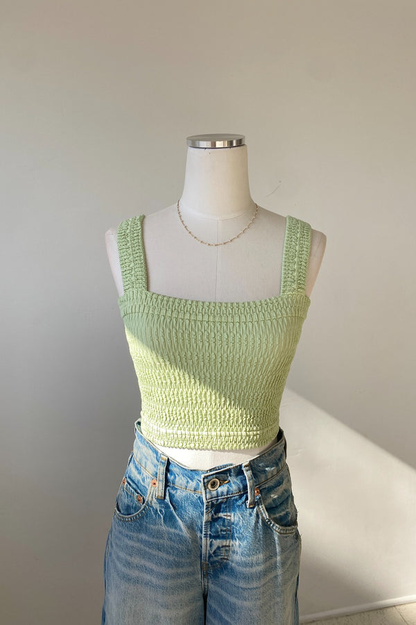 Light green knitted top on a mannequin with a plain background