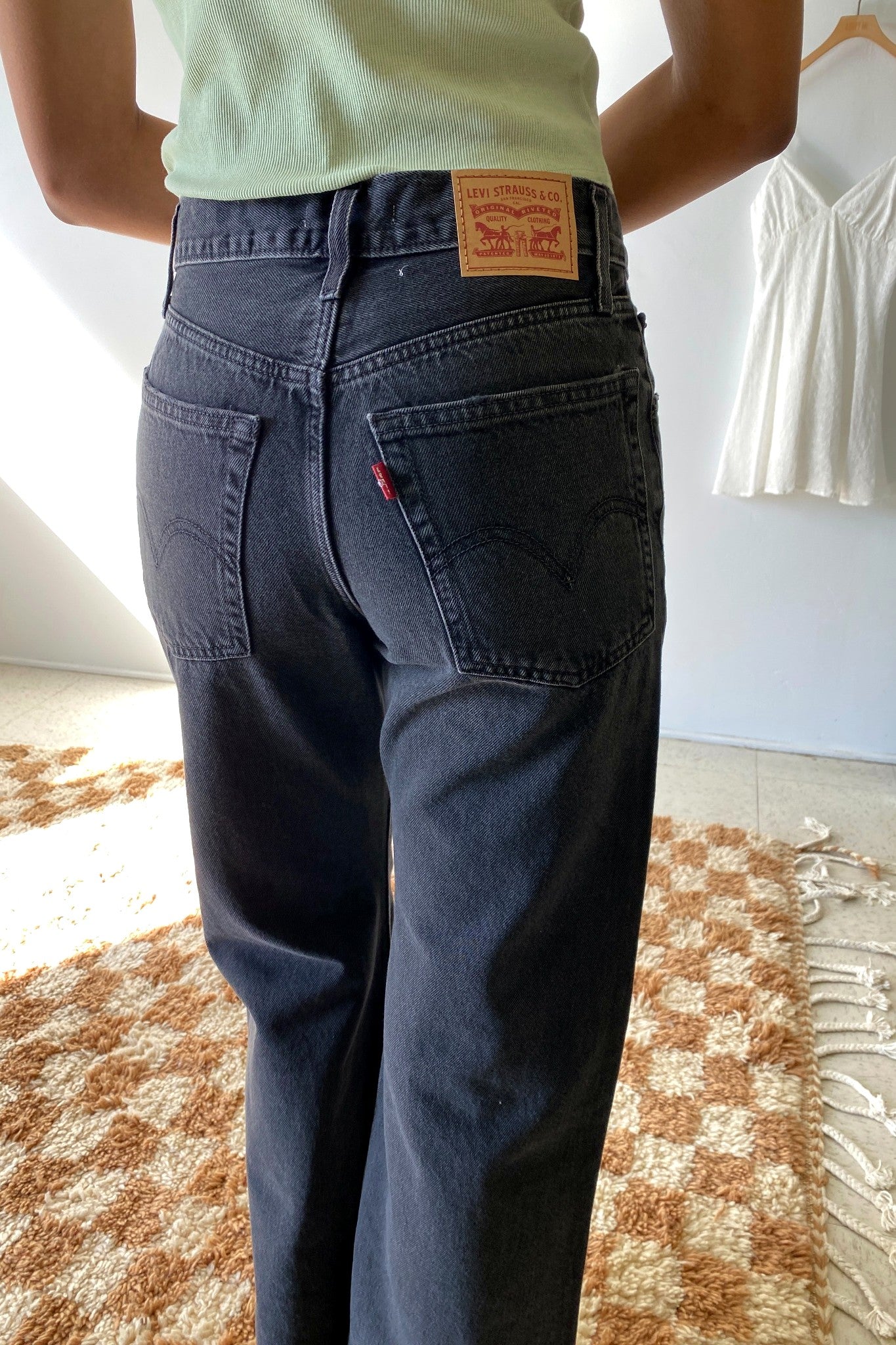 Person wearing Levi's jeans with a visible brand patch in a room.