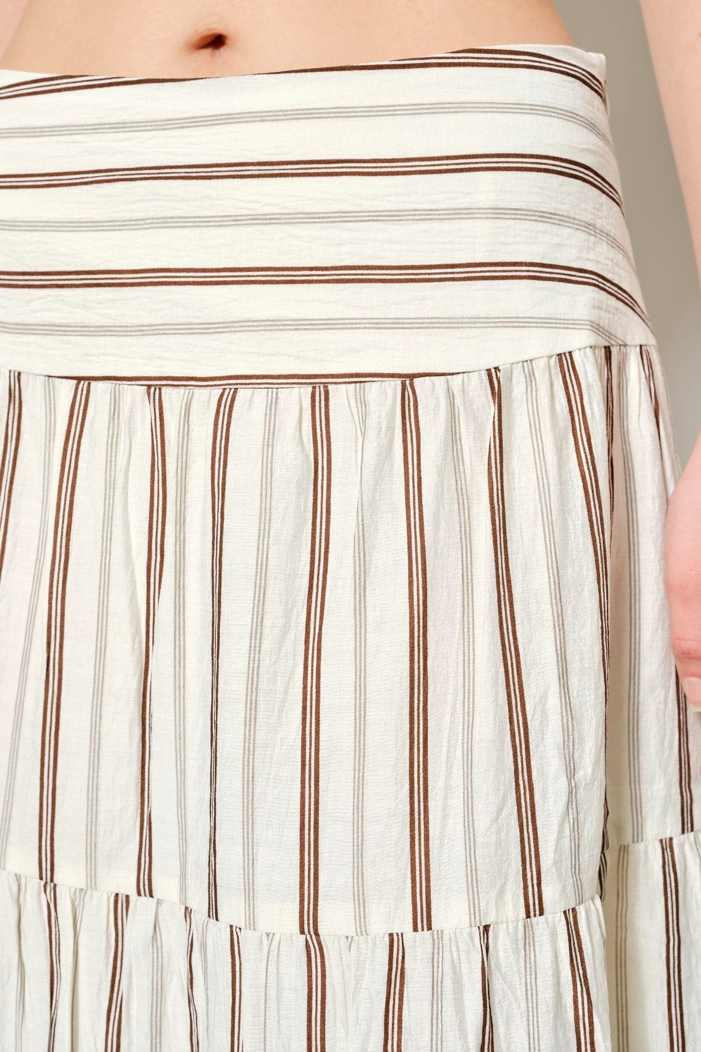 Close-up of a striped skirt with white and brown horizontal lines.