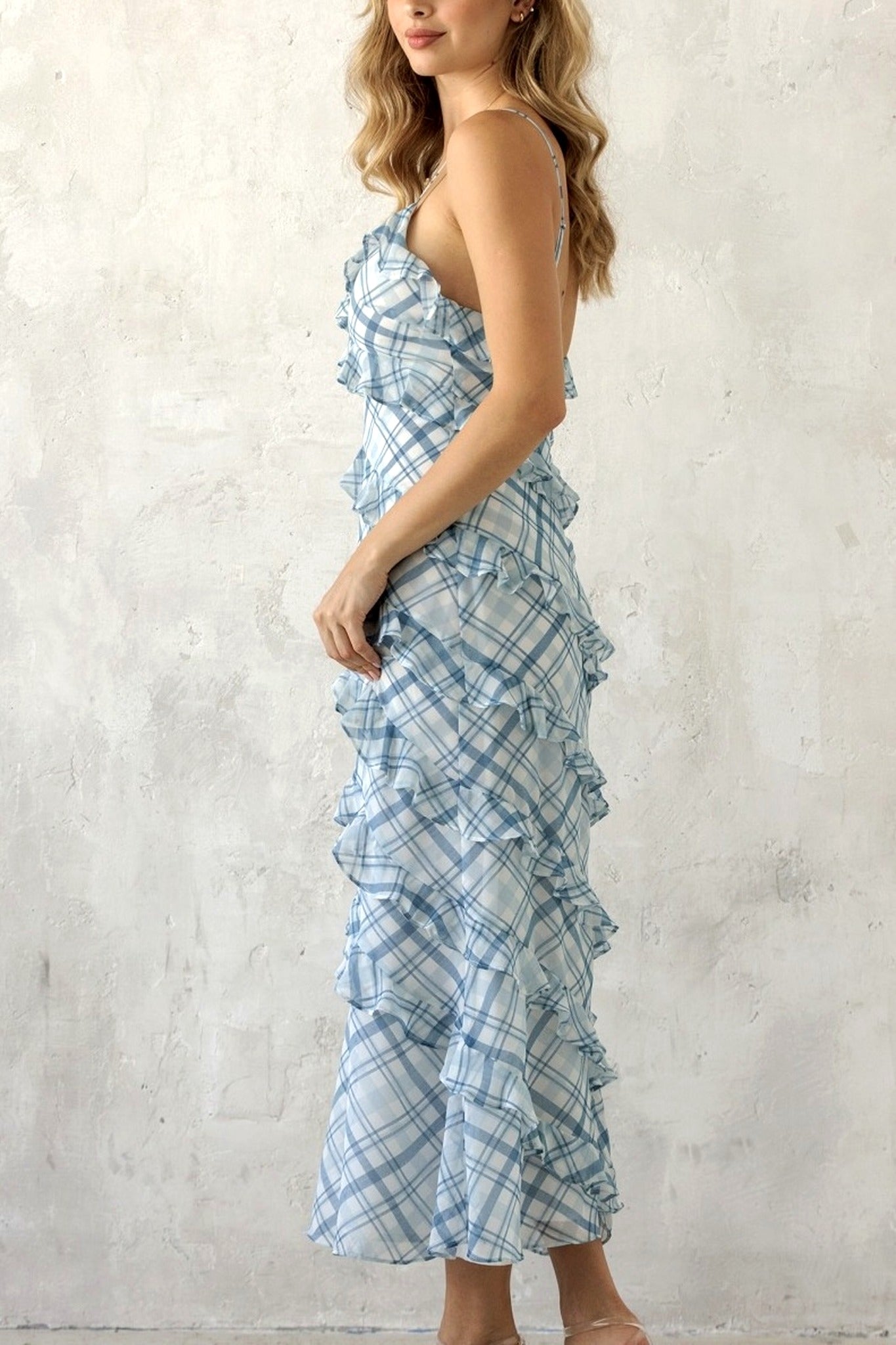 Woman wearing a blue plaid dress against a white background
