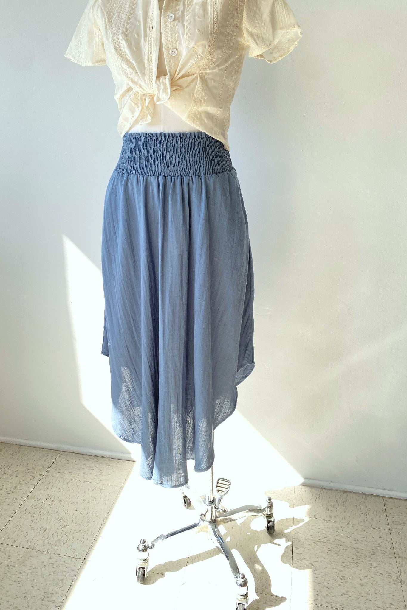 Light blue skirt on a mannequin against a white wall