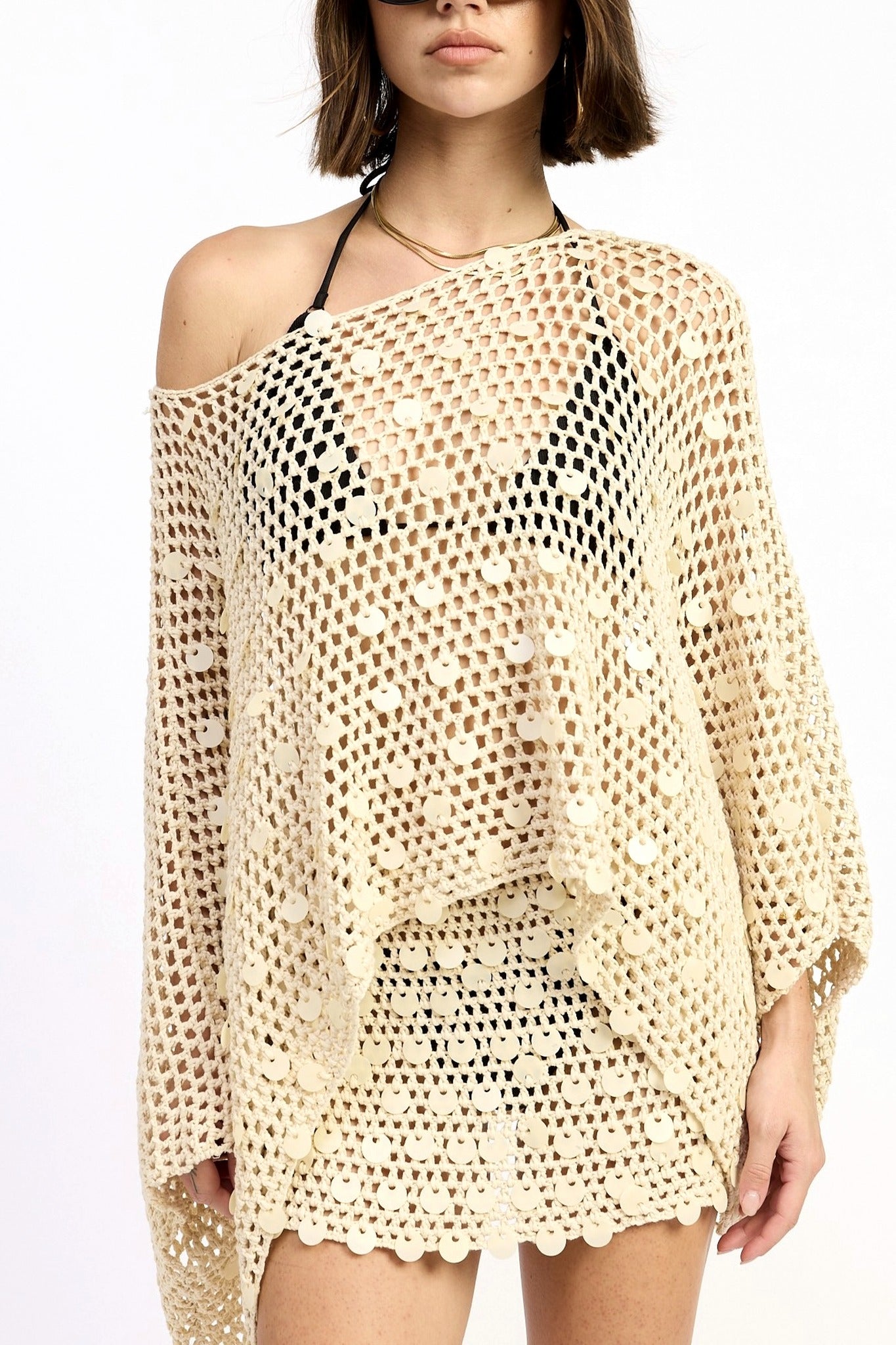 Beige crochet cover-up worn by a model on a white background