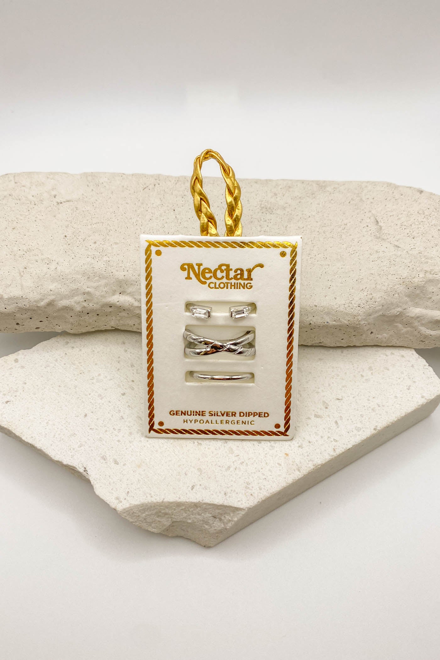 Nectar Clothing jewelry tag with silver earrings on a stone surface