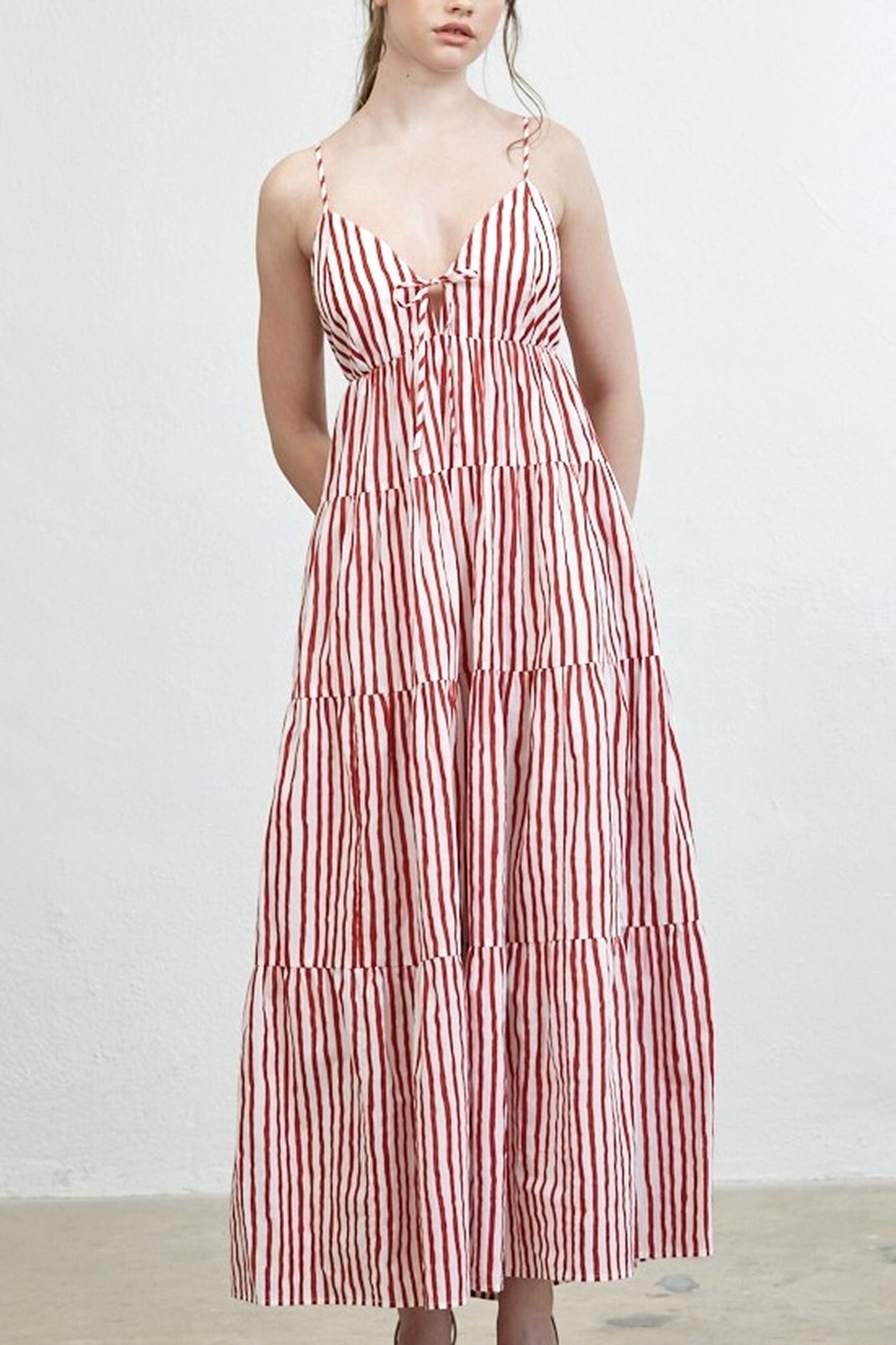 Woman wearing a red and white striped dress against a plain background