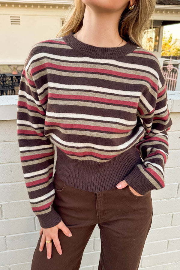 Person wearing a striped sweater with a blurred background