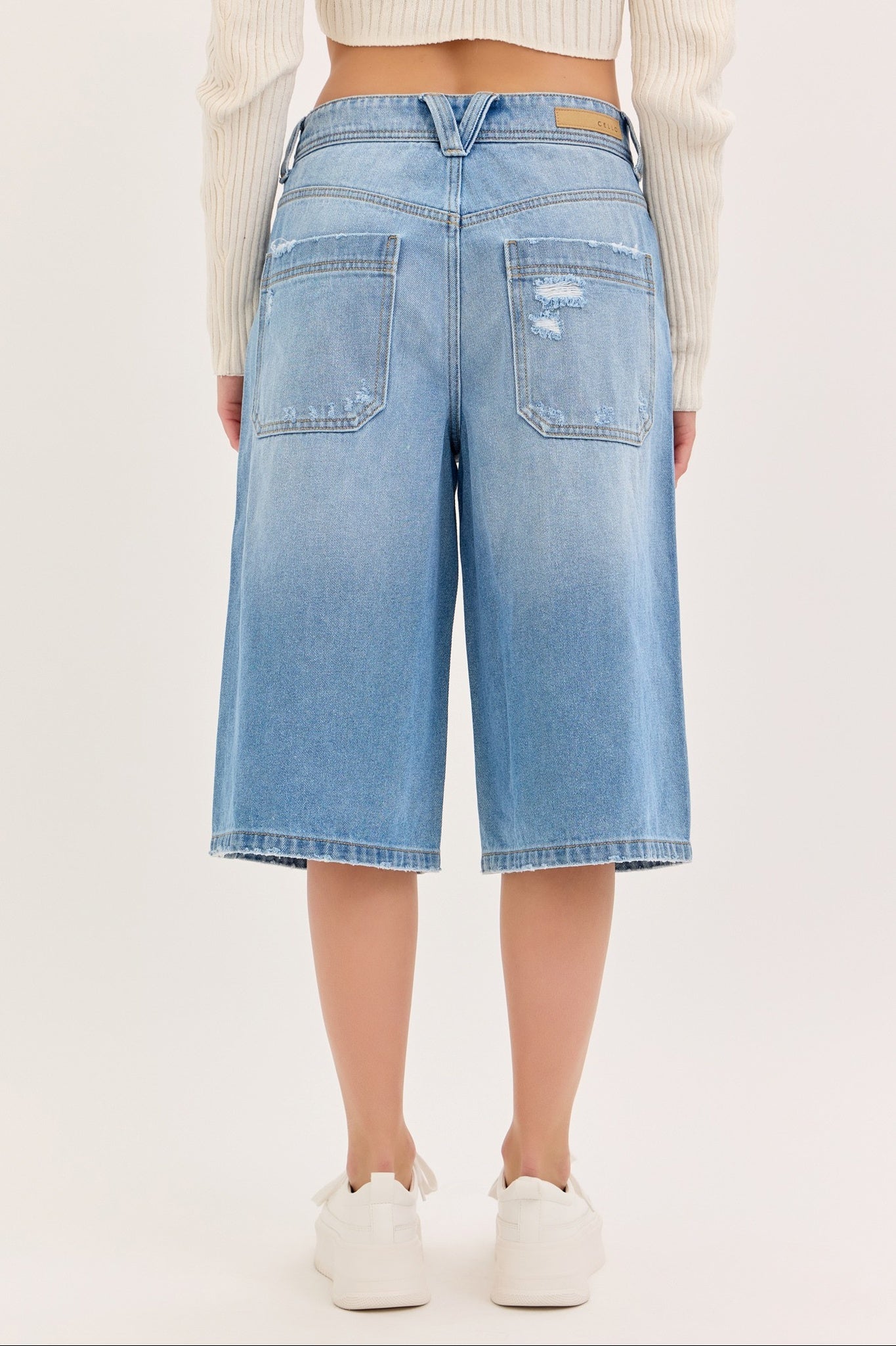 Light blue denim shorts worn by a person on a plain background