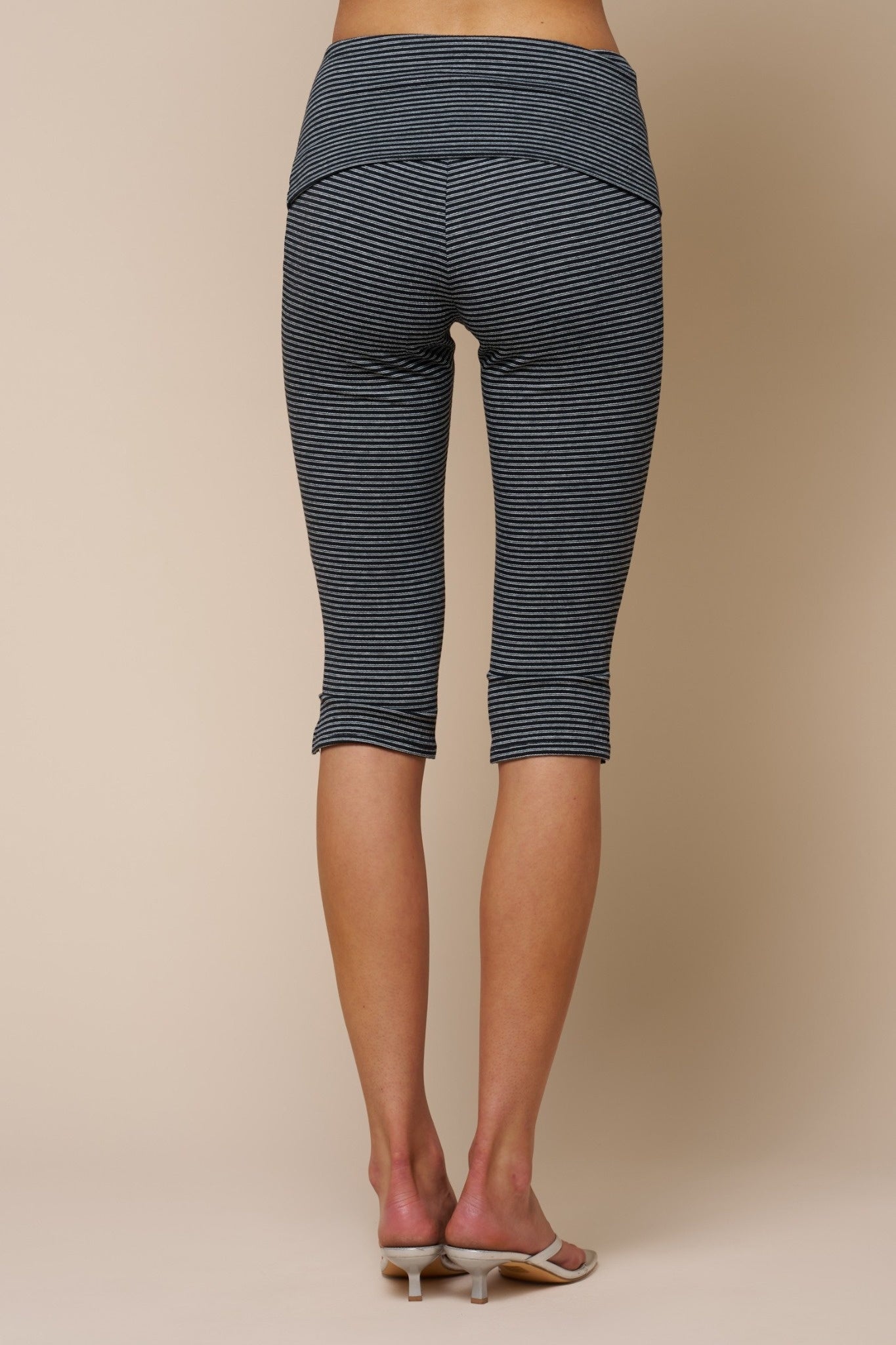 Black and white striped capri leggings on a beige background