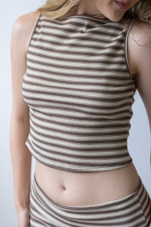 Person wearing a sleeveless striped top and skirt on a plain background