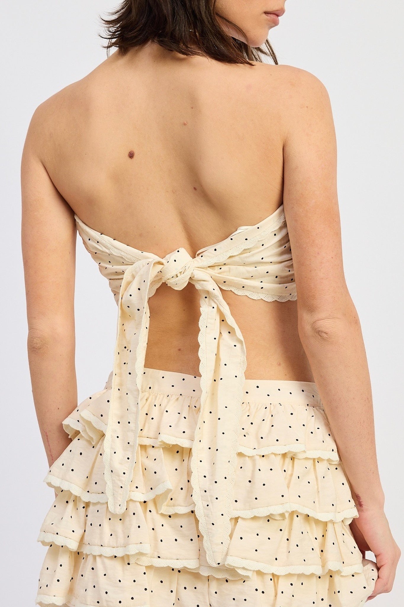 Beige polka dot dress with ruffled layers on a white background