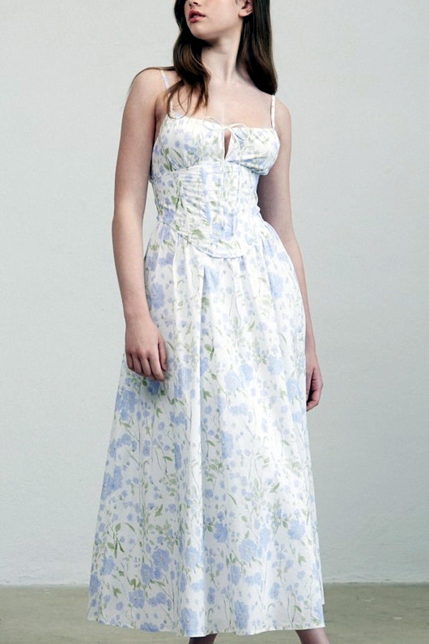Woman wearing a floral dress against a plain background
