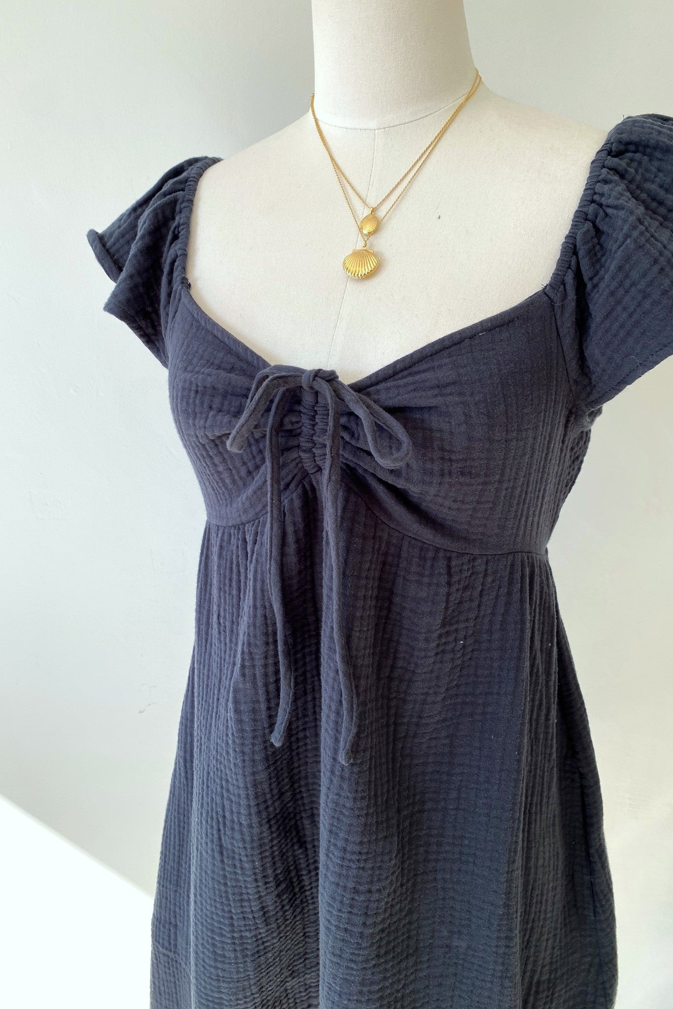 Navy blue dress on a mannequin with a white background
