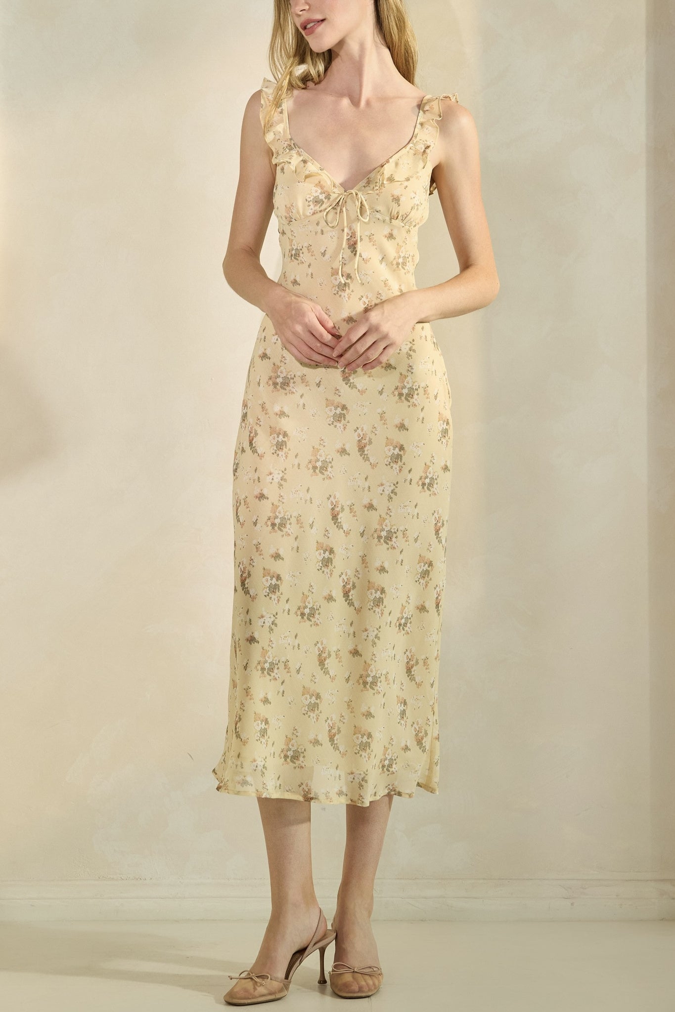 Woman wearing a floral dress against a plain background