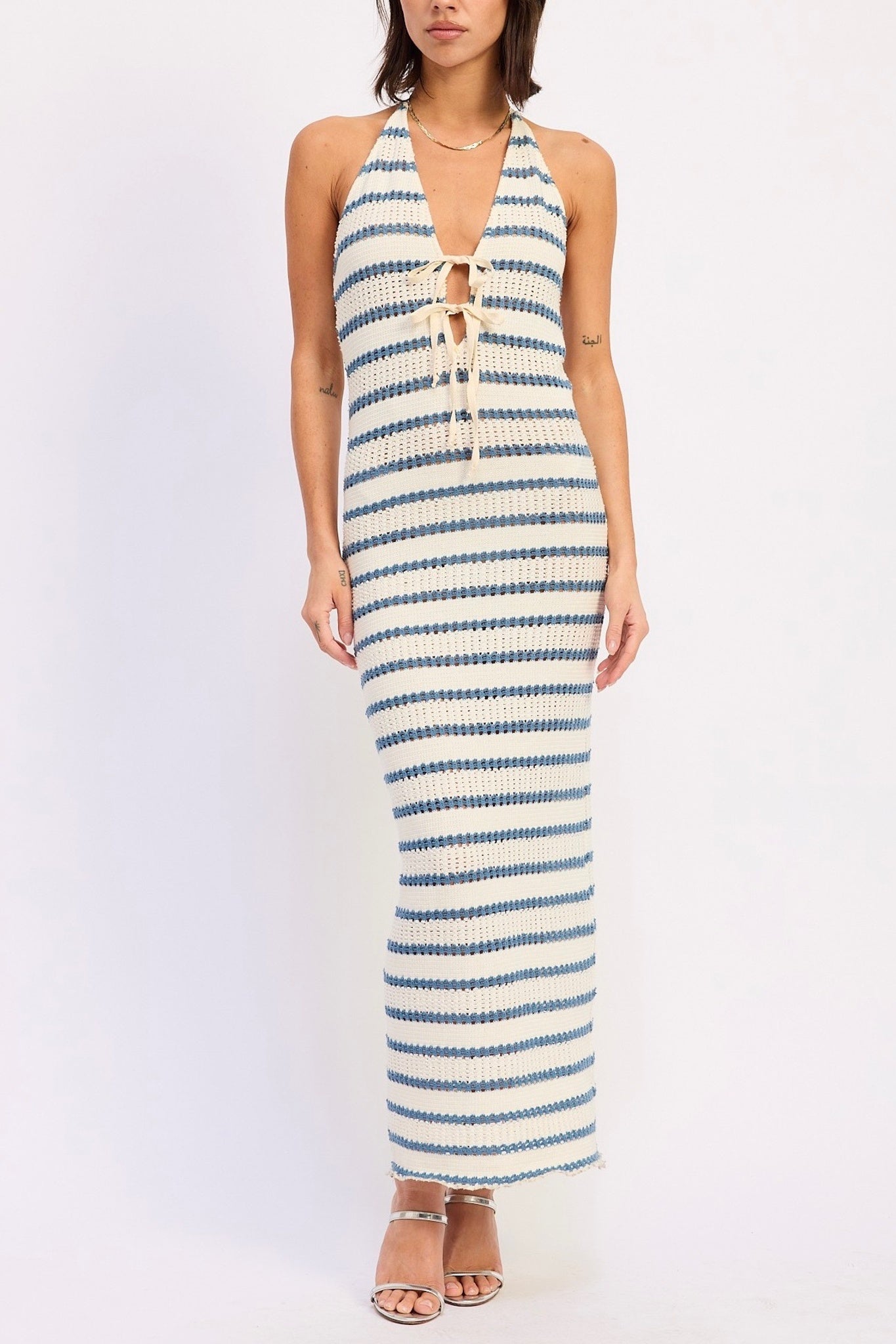 Woman wearing a blue and white striped halter neck dress on a white background