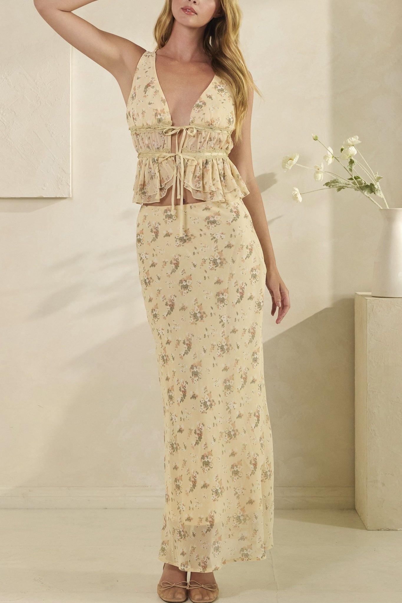 Woman wearing a floral dress in a minimal indoor setting