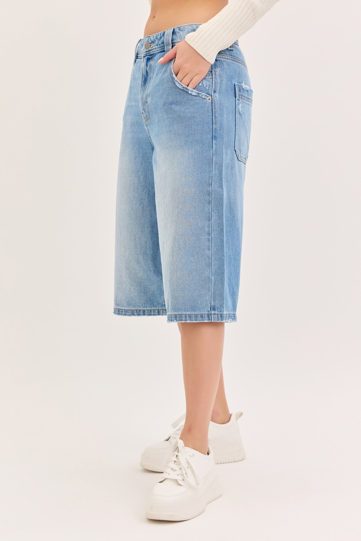 Light blue denim shorts worn by a person on a white background