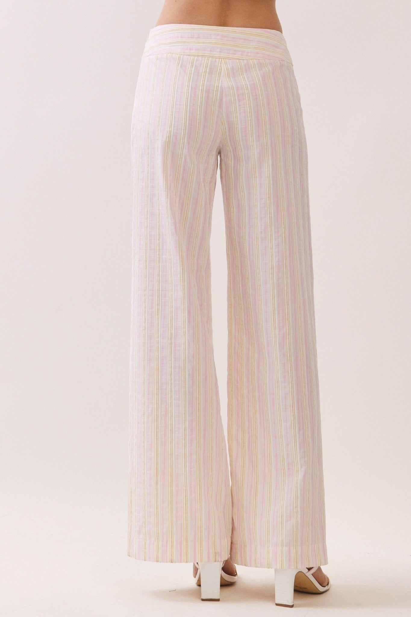 Striped pants worn by a person on a white background