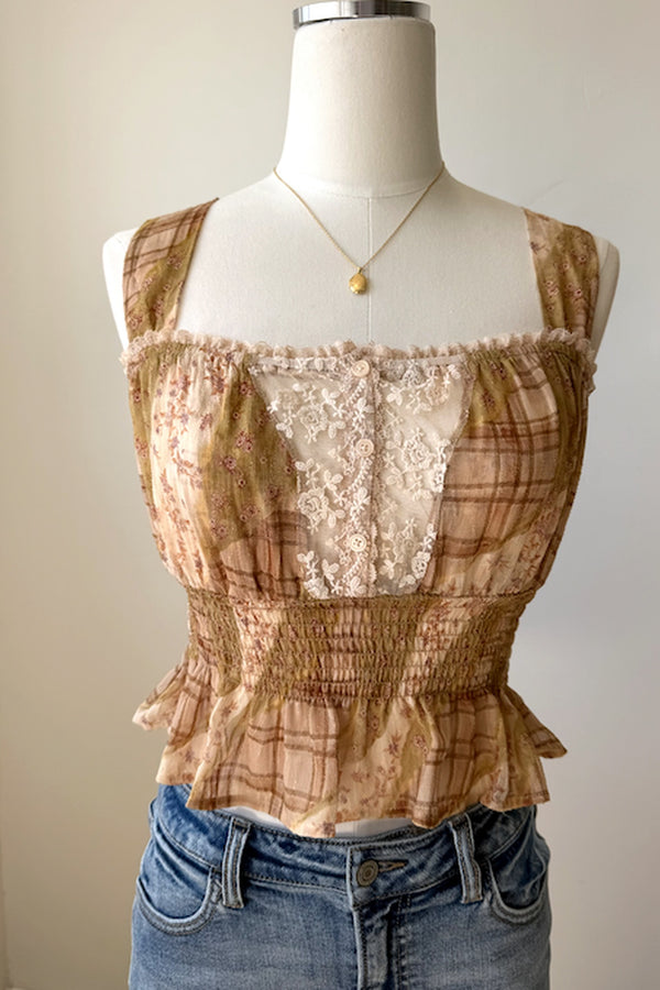 Brown lace top on a mannequin with a plain background