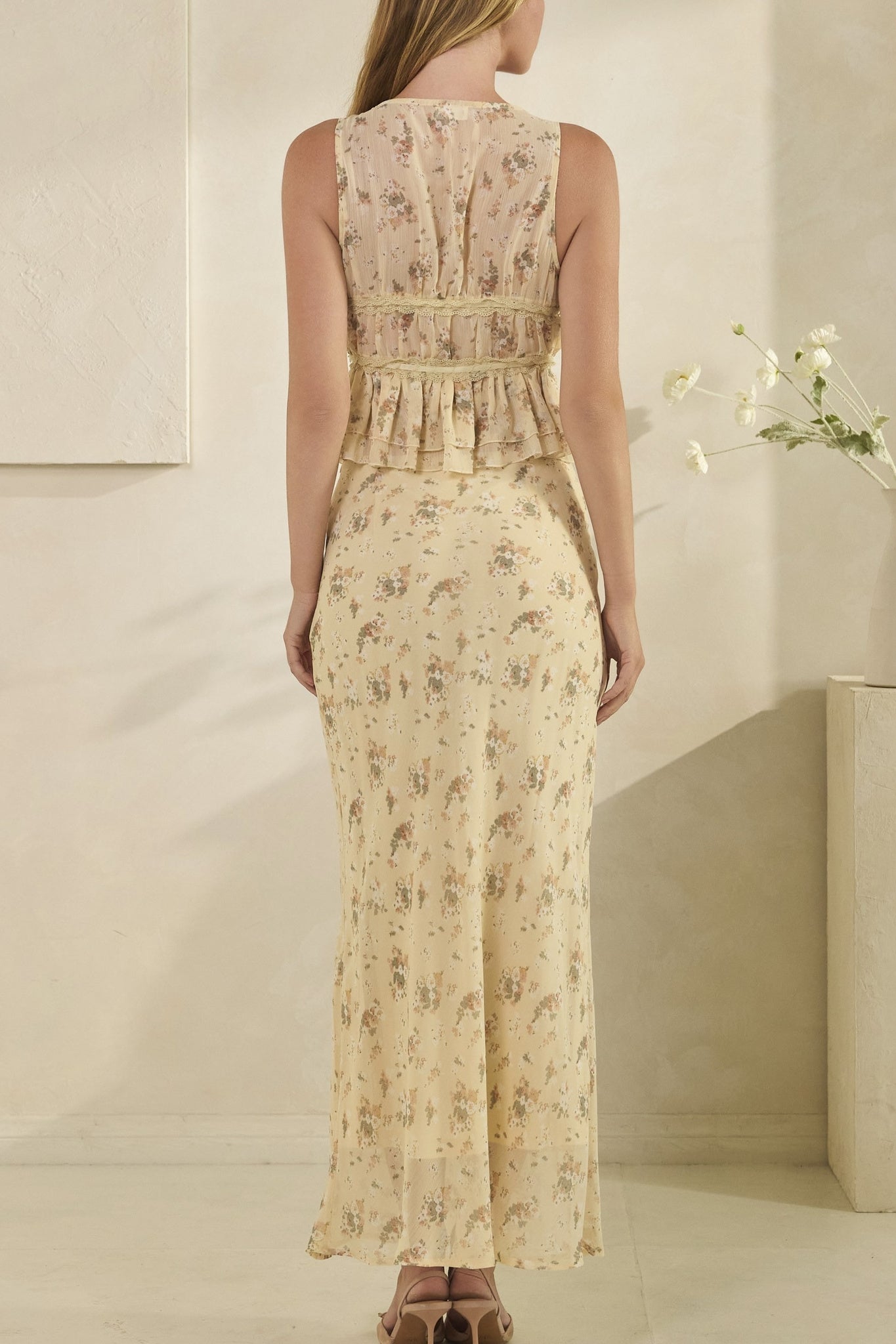 Woman wearing a floral dress in a minimal indoor setting