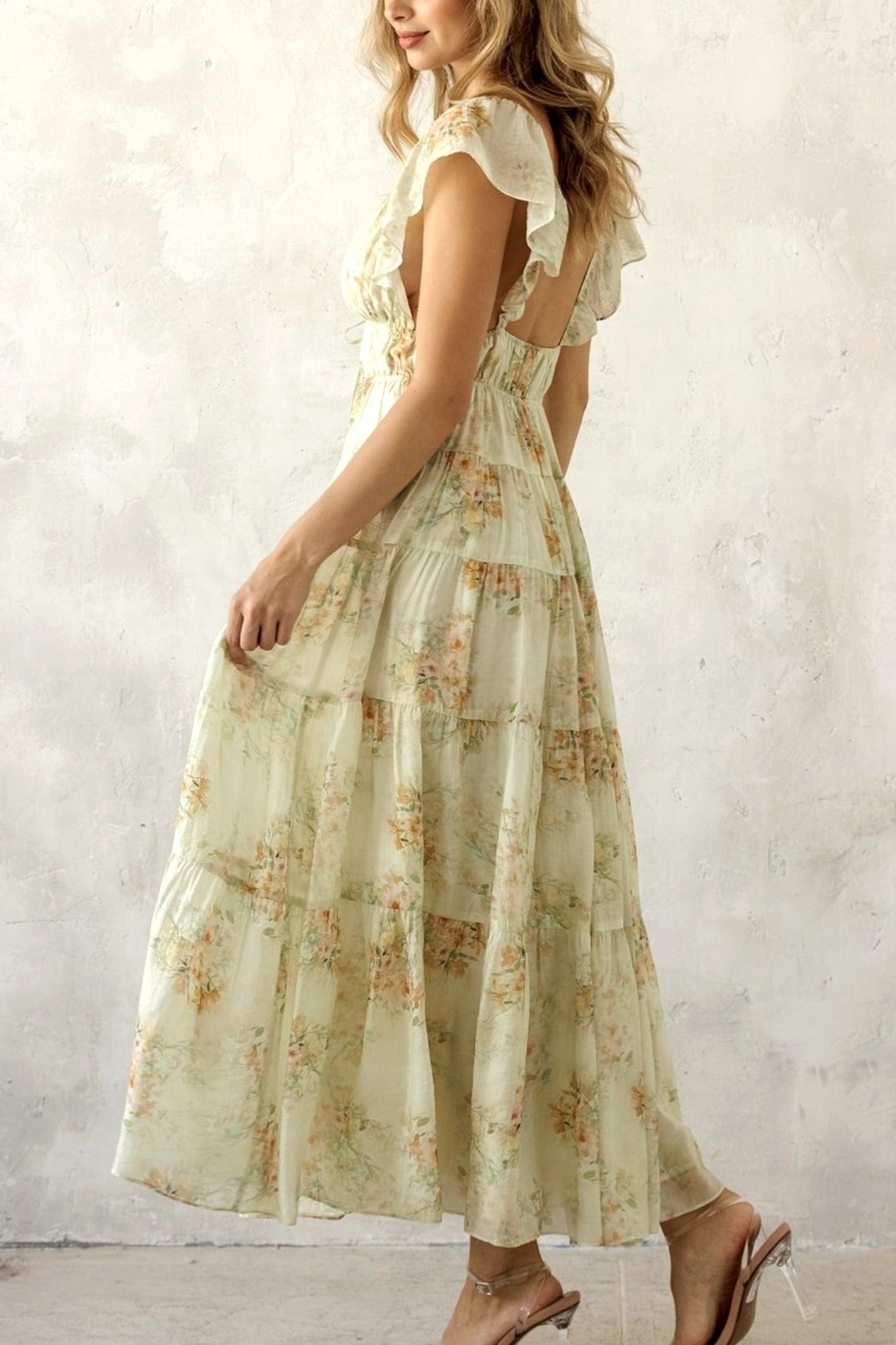 Woman wearing a floral dress against a plain background