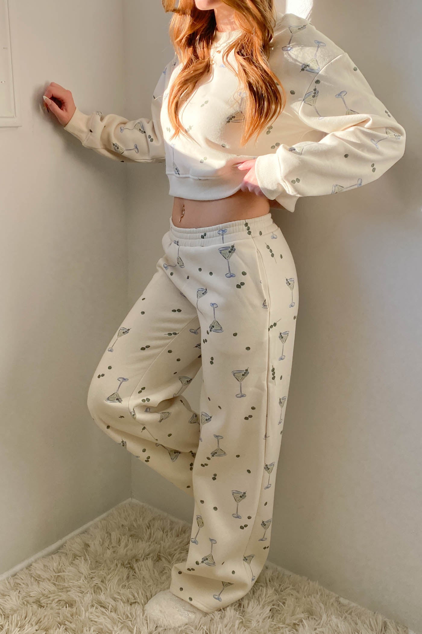 Person wearing a white pajama set with small patterns in a minimal indoor setting