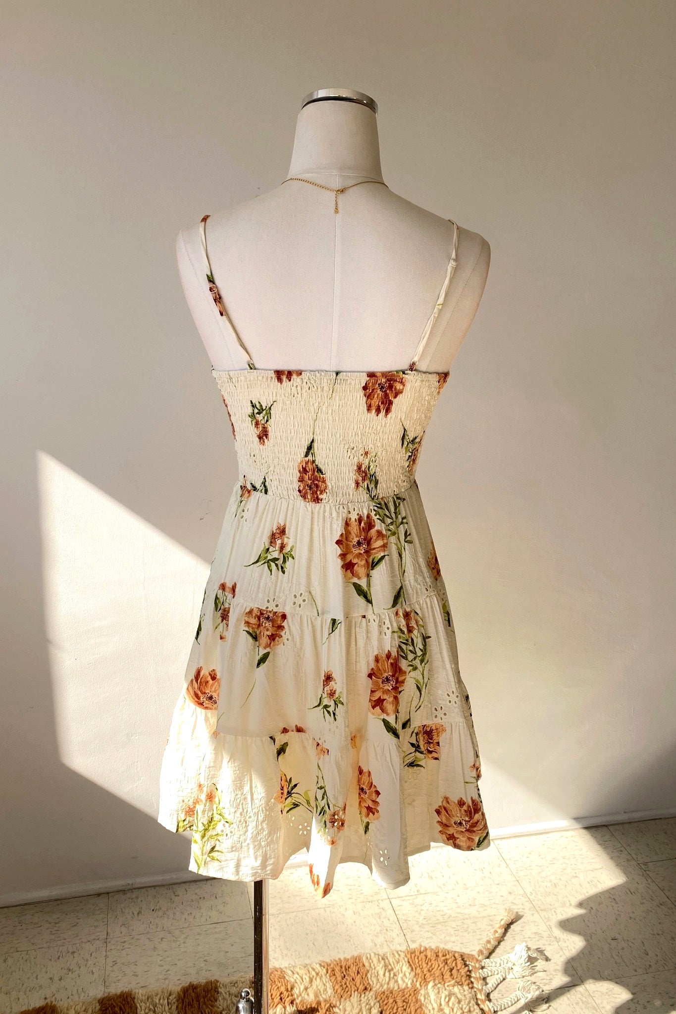 Floral dress on a mannequin against a plain background