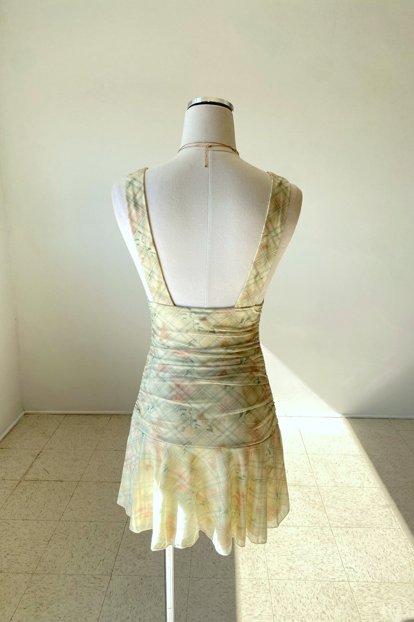 Floral dress on a mannequin against a plain background