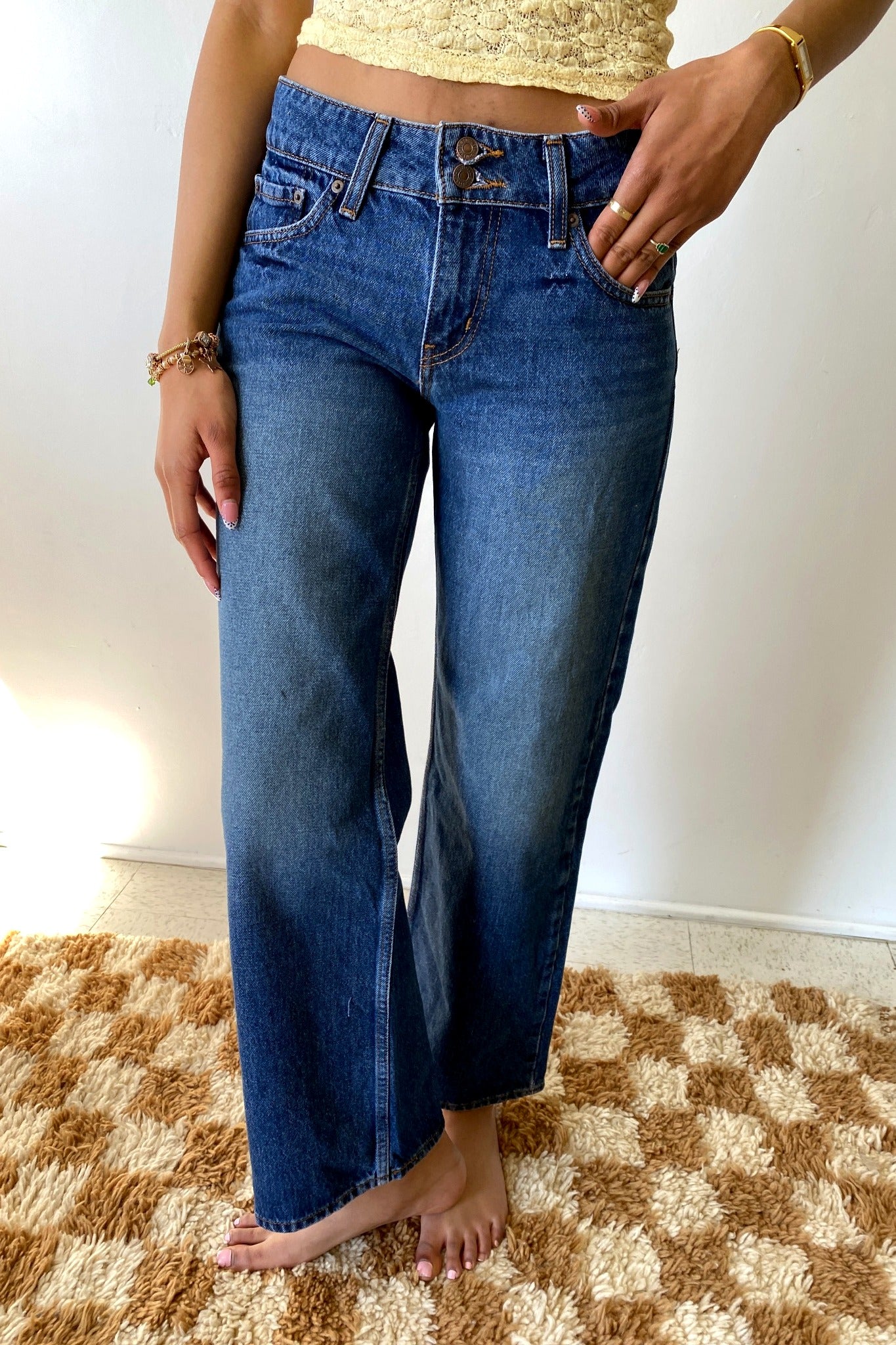 Person wearing blue jeans on a checkered floor