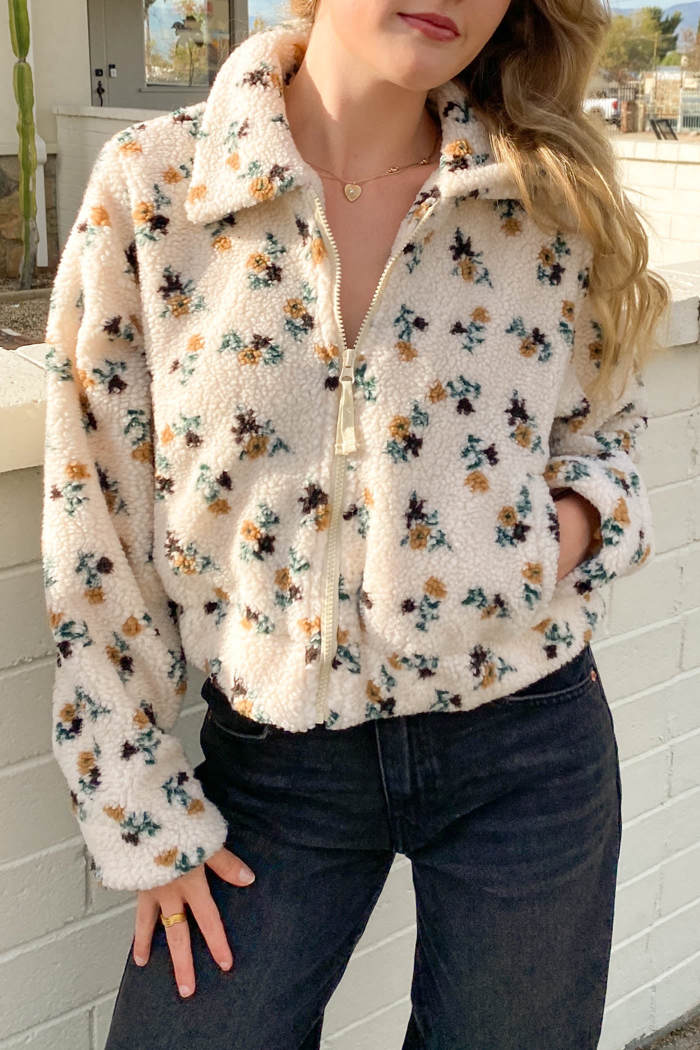 Person wearing a floral patterned fleece jacket in an outdoor setting.