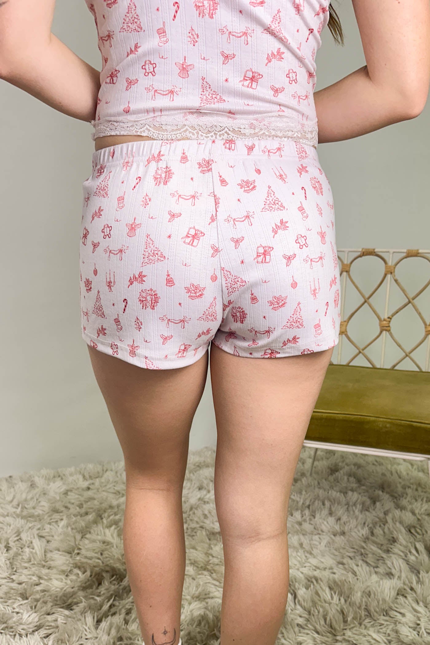 Person wearing a pink and white patterned outfit with shorts on a neutral background