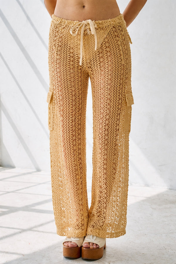 Beige crochet pants worn by a person on a white background