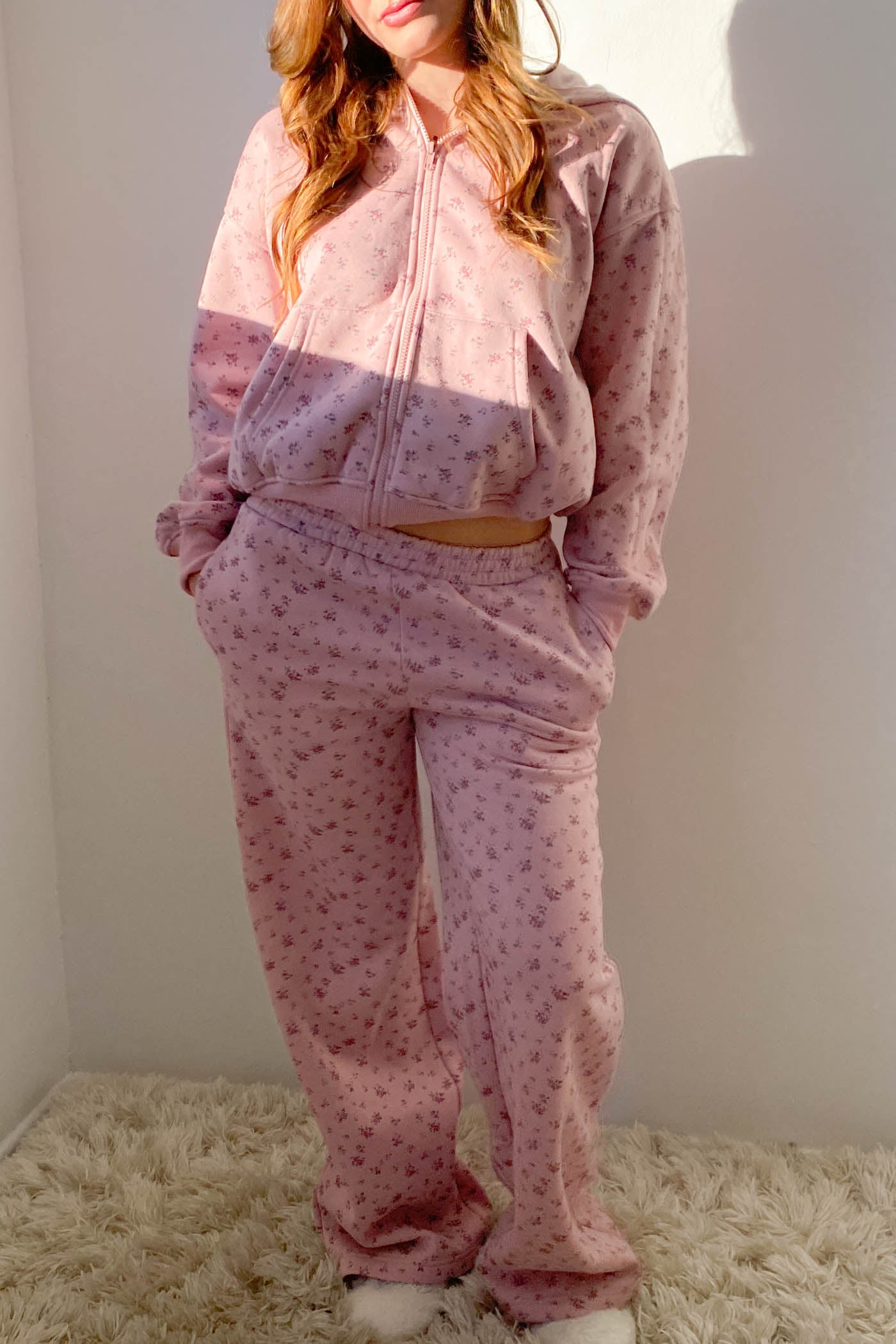 Person wearing a pink pajama set with a subtle pattern on a white background